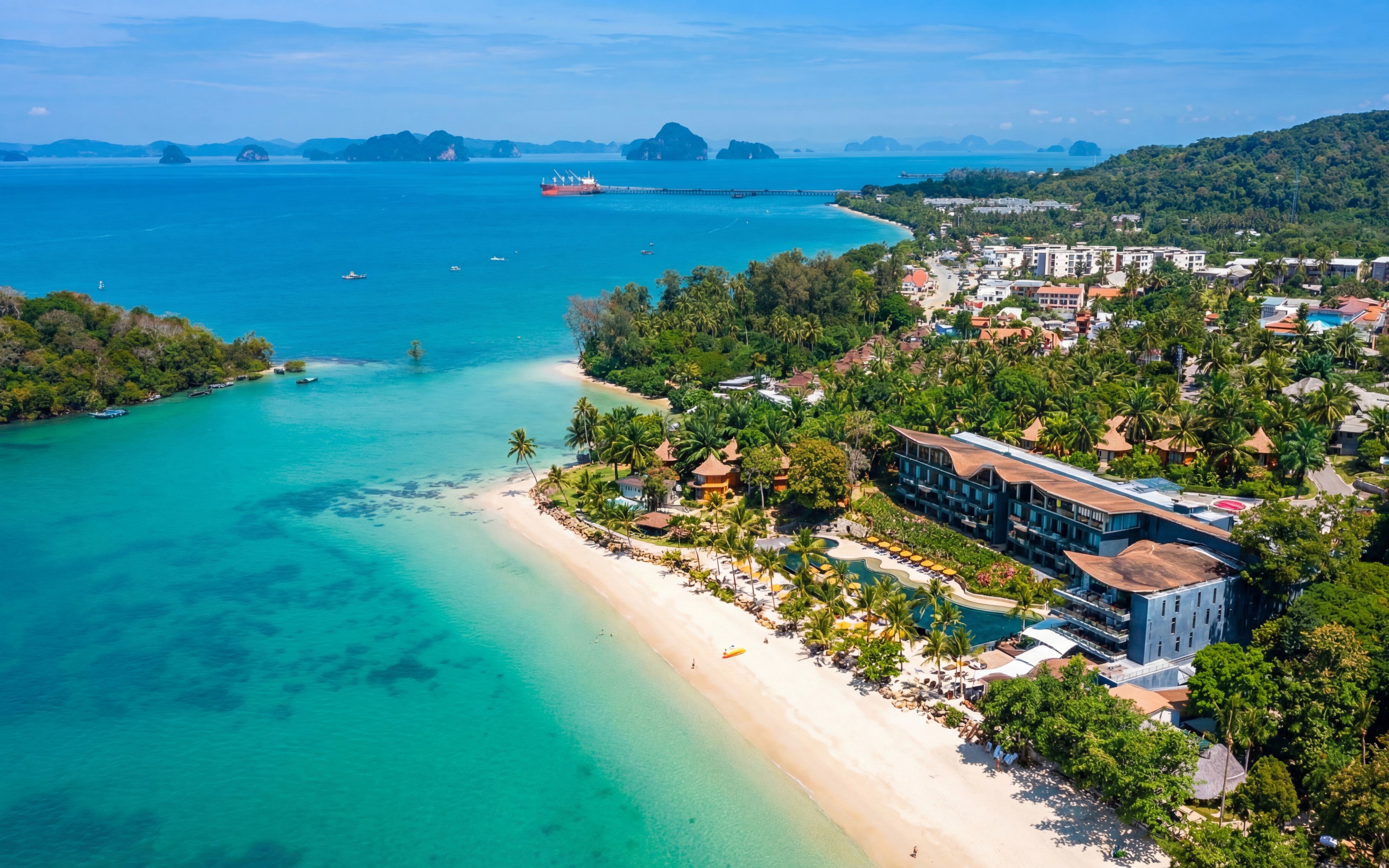 Aerial view of Klong Muang in Krabi, showing a quiet beachfront, low-density resorts, and surrounding greenery.