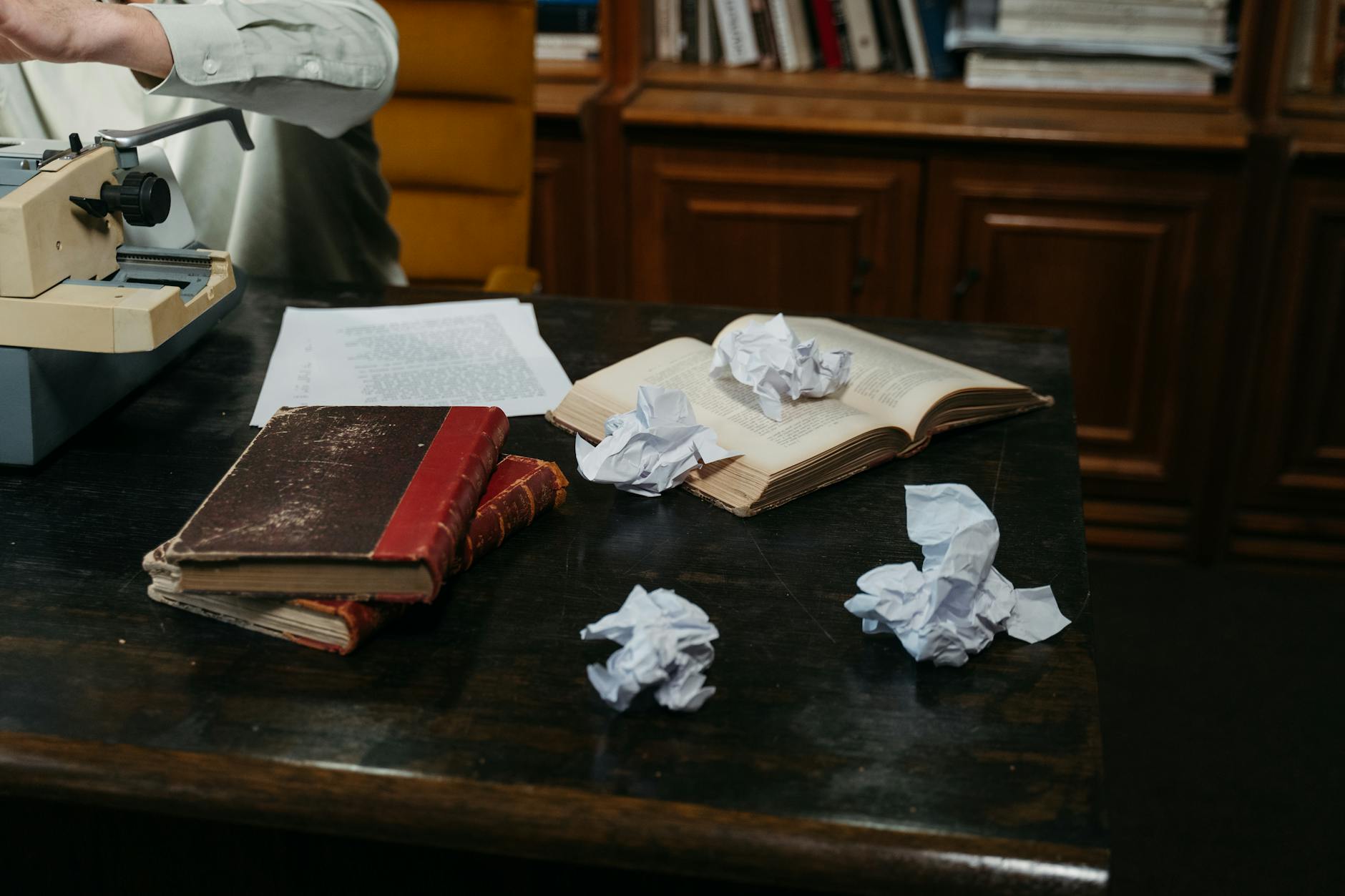 Close-up of a messy wooden desk with scattered sticky notes, open textbooks, and a half-full coffee mug.