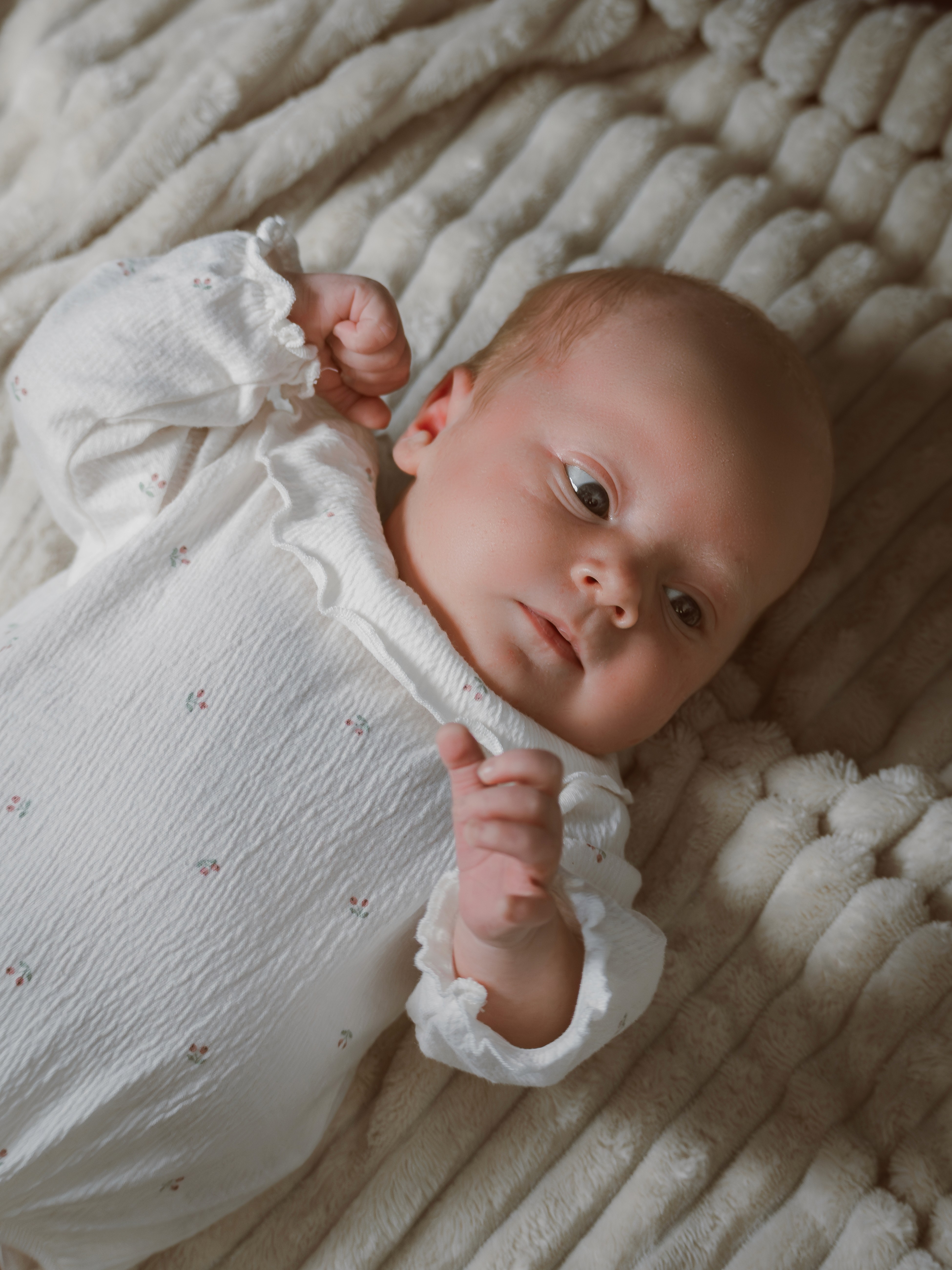 Nyfødtfotografering av liten jente i dokumentarisk stil. Varme og ekte øyeblikk fanget hjemme.