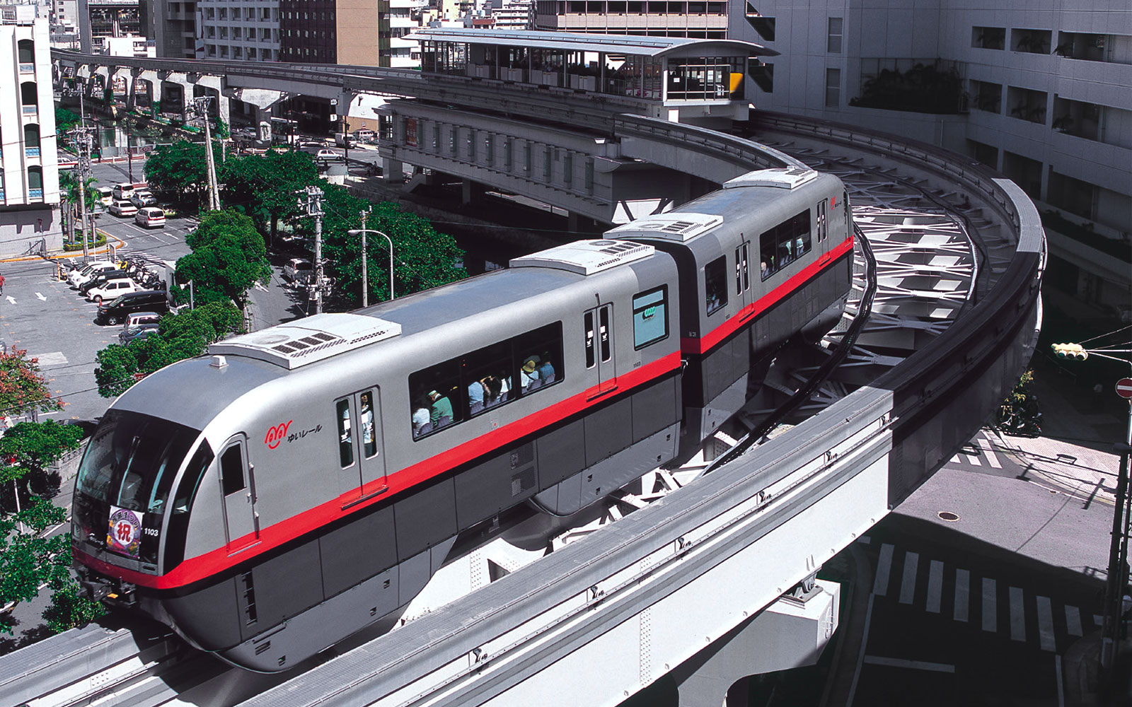 Το τρένο του Μονορέιλ Οκινάουα ταξιδεύει μέσα από το αστικό τοπίο στη Νάχα της Ιαπωνίας.