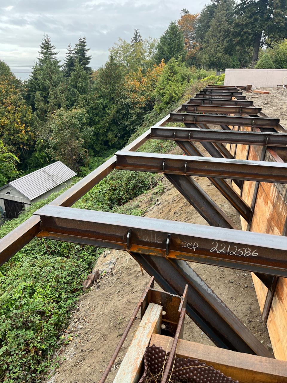 Steel deck beams and diagonal supports along a steep site
