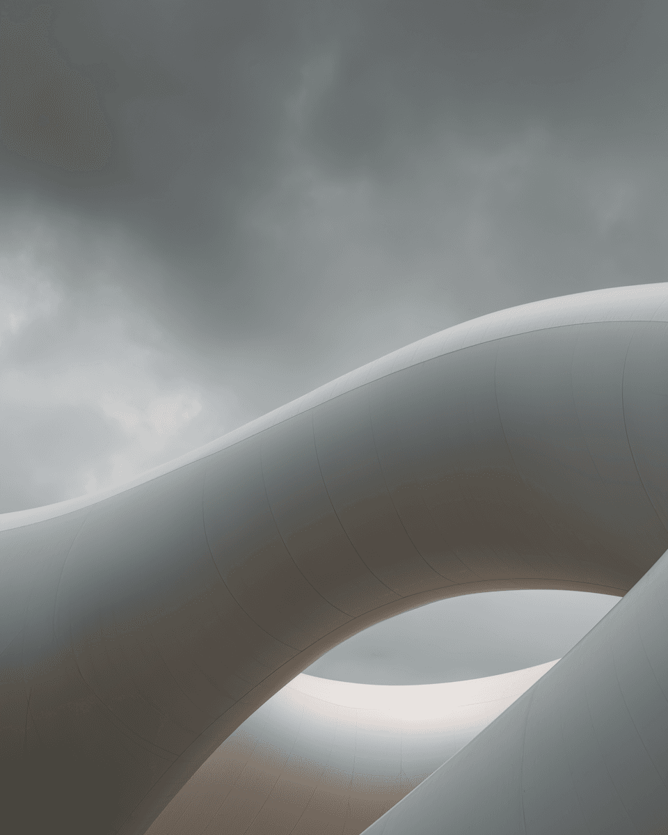 Modern architectural structure with sweeping curves and sharp angles, featuring a sleek white facade and dynamic silhouette.