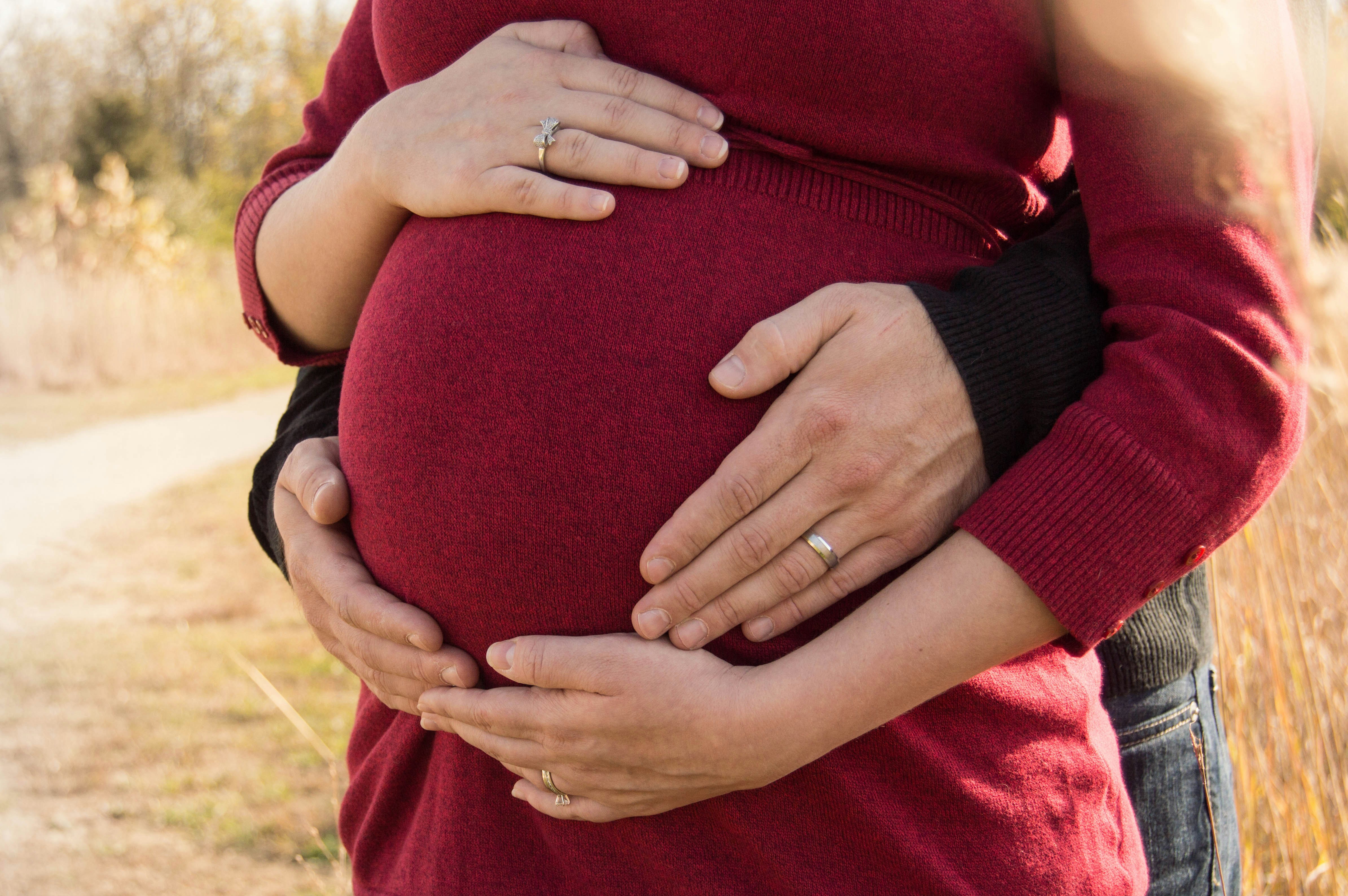 woman posing with husband - Fall Pregnancy Outfits