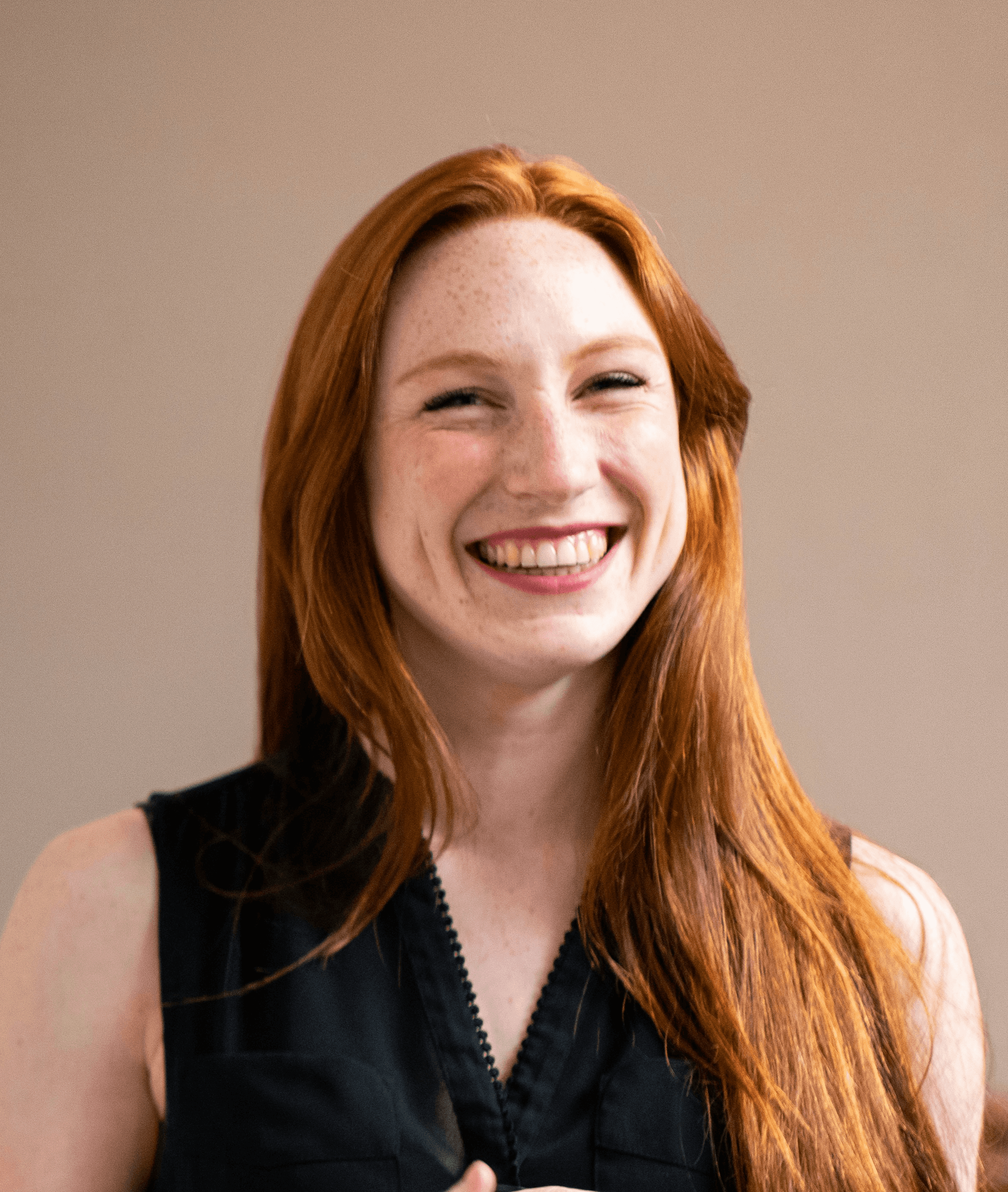 woman in blue tank top standing beside white wall