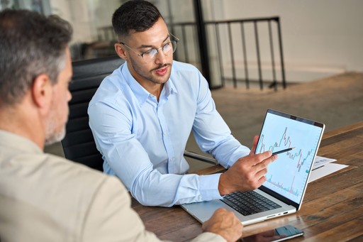Business expert explaining compliance diagrams on laptop to client, representing GPSR and EU regulatory consulting.