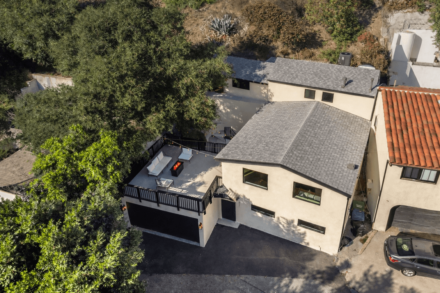 Modern house with elevated glass balcony and hillside view