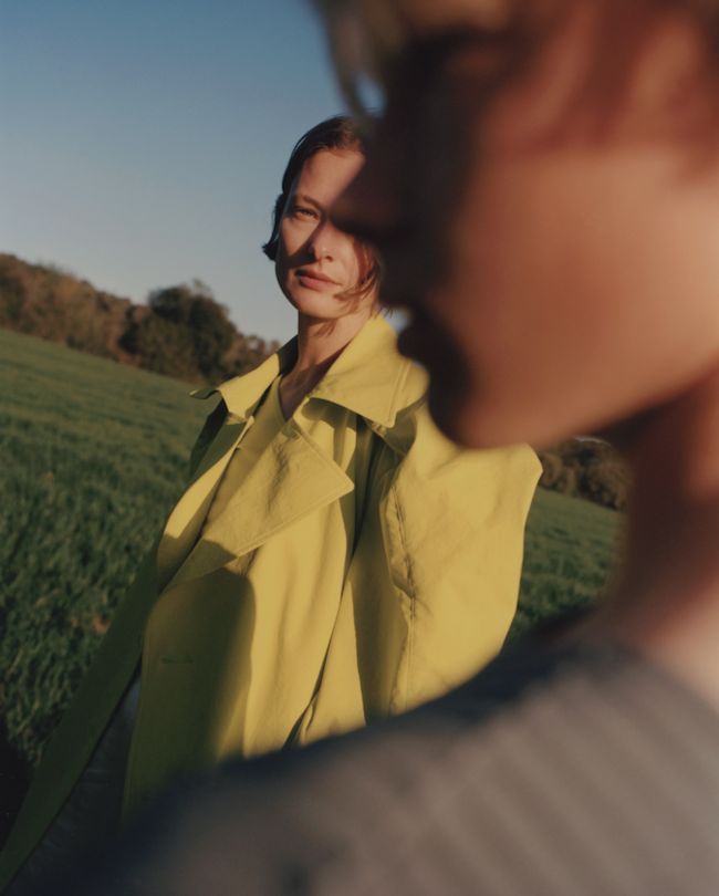 Two fathers carrying children on shoulders on a mountain path.