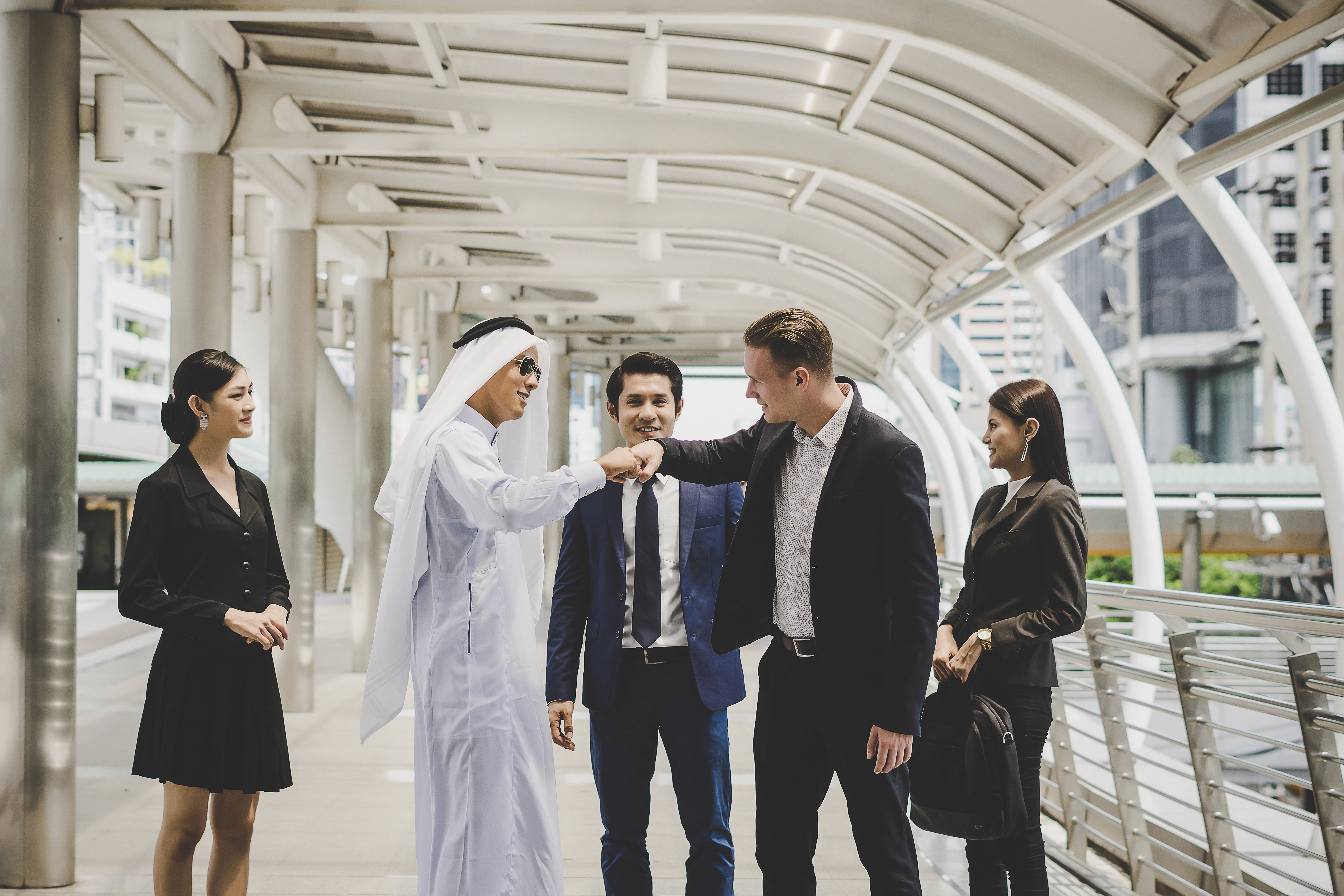 Business partners shaking hands to celebrate a business agreement during a professional gathering at the Dubai International Financial Centre.