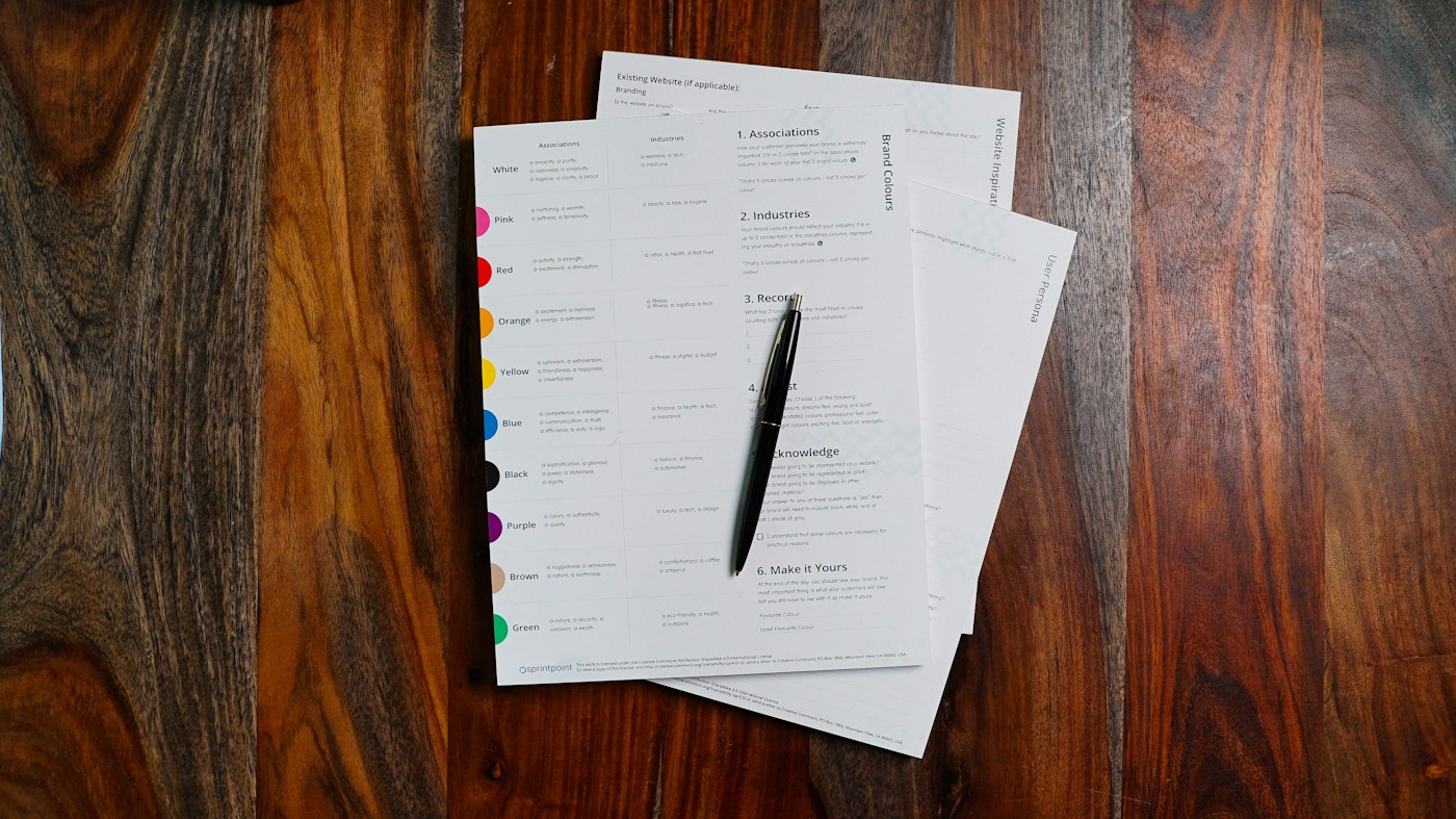 stack of paper envelopes and a pen on a desk
