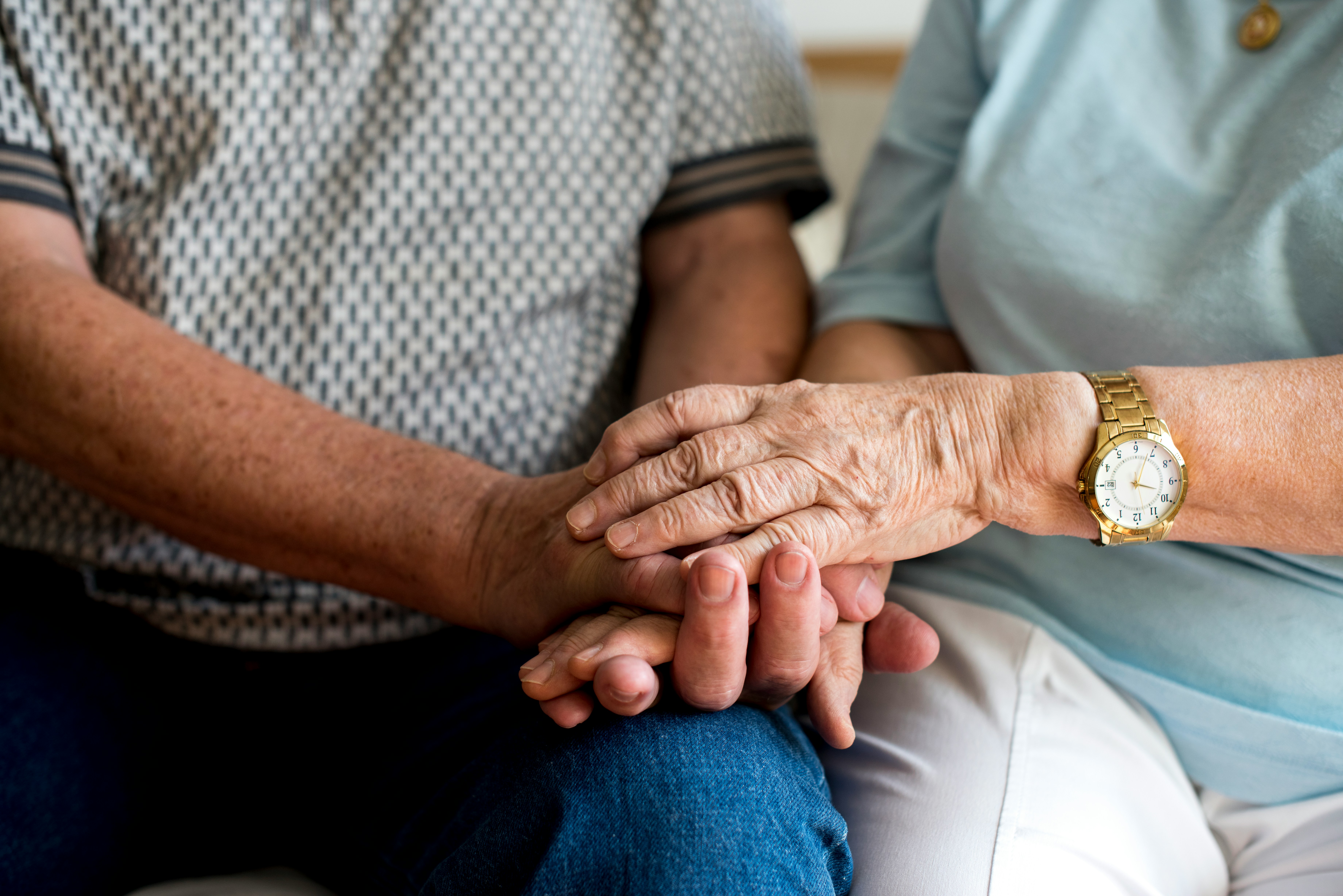 A elderly couple holding hands during therapy