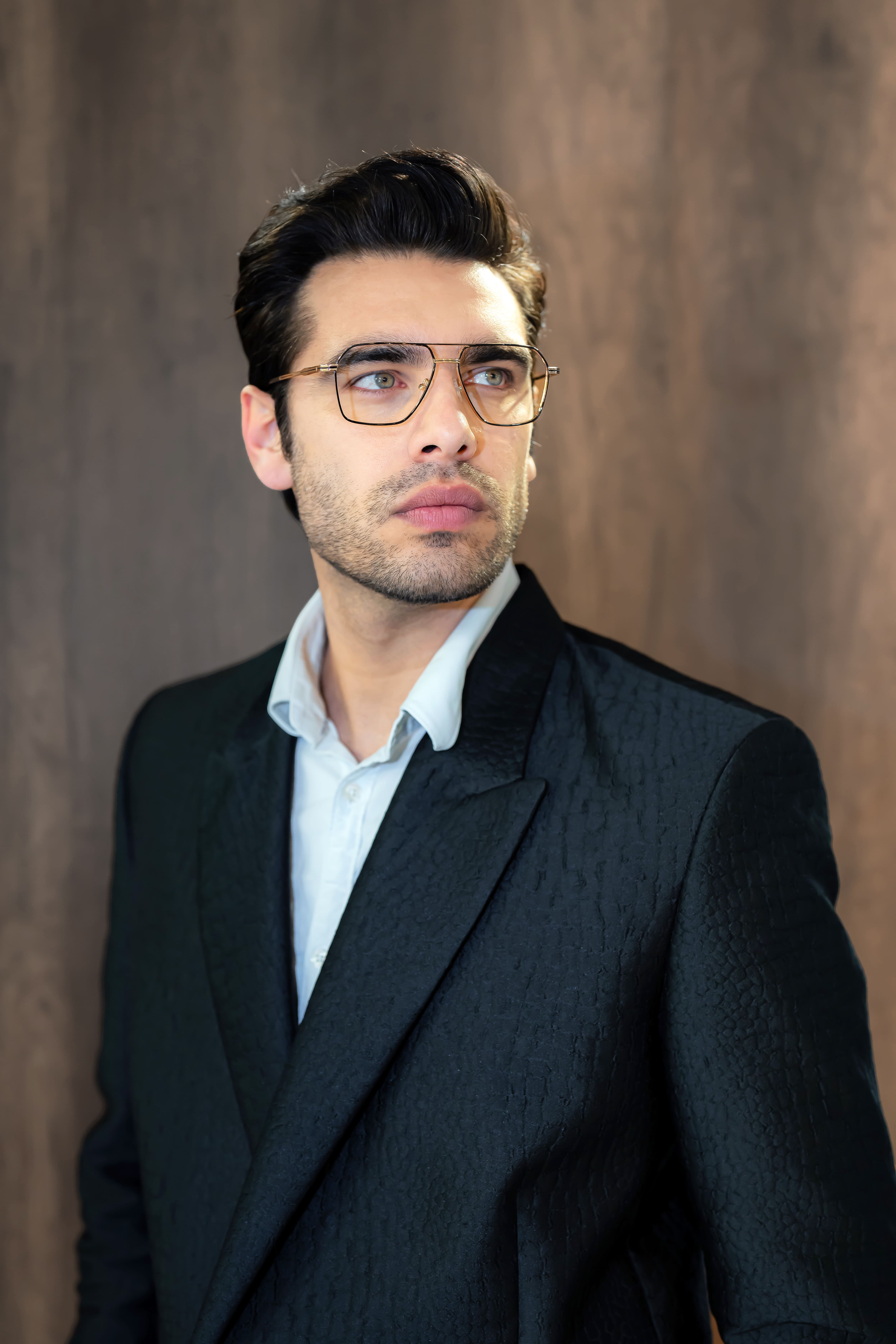 Close-up of lush, dark green leaves, some glossy and wet, against a muted background.