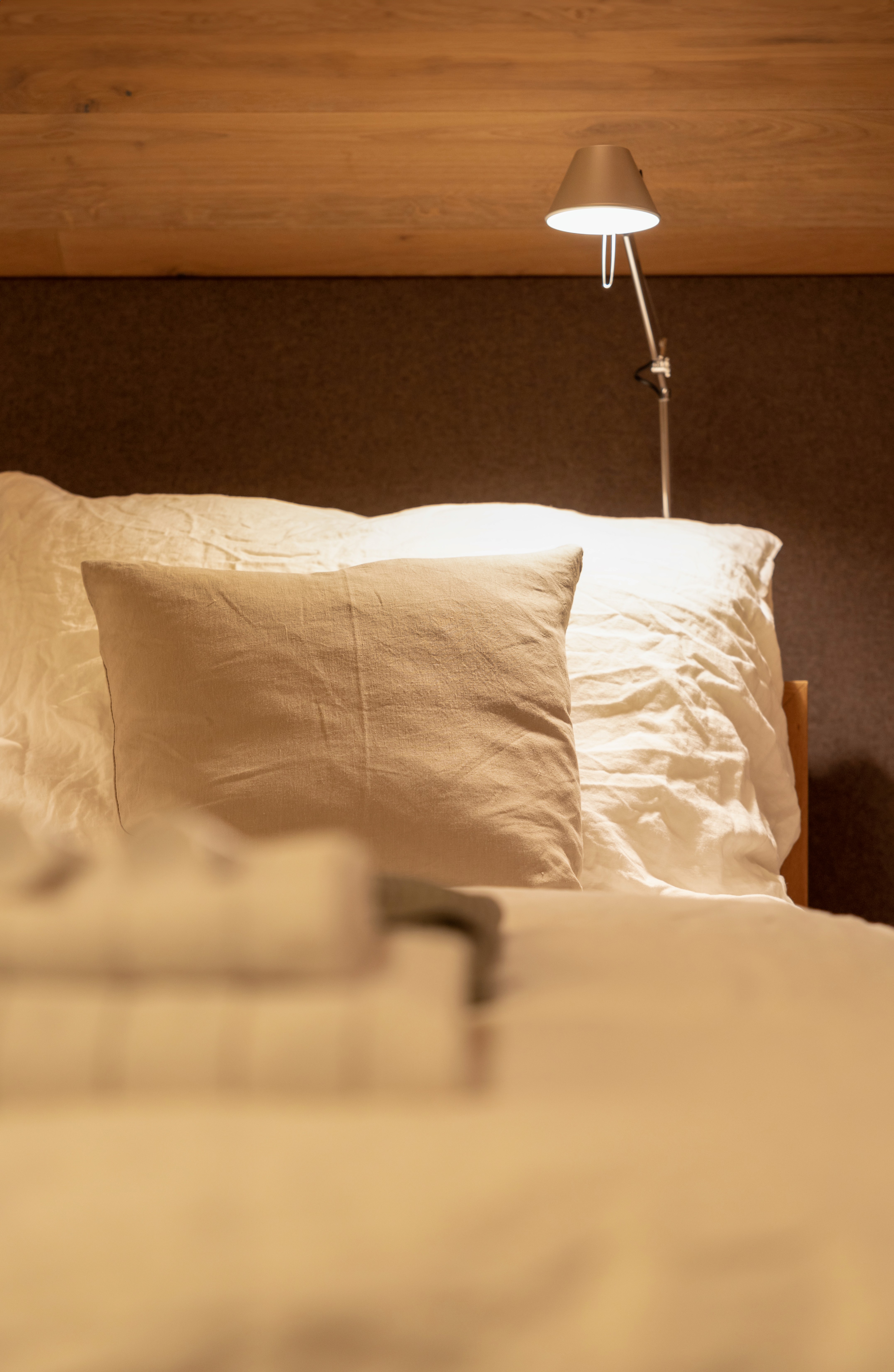 Detail picture of a bed with pillows and a lamp