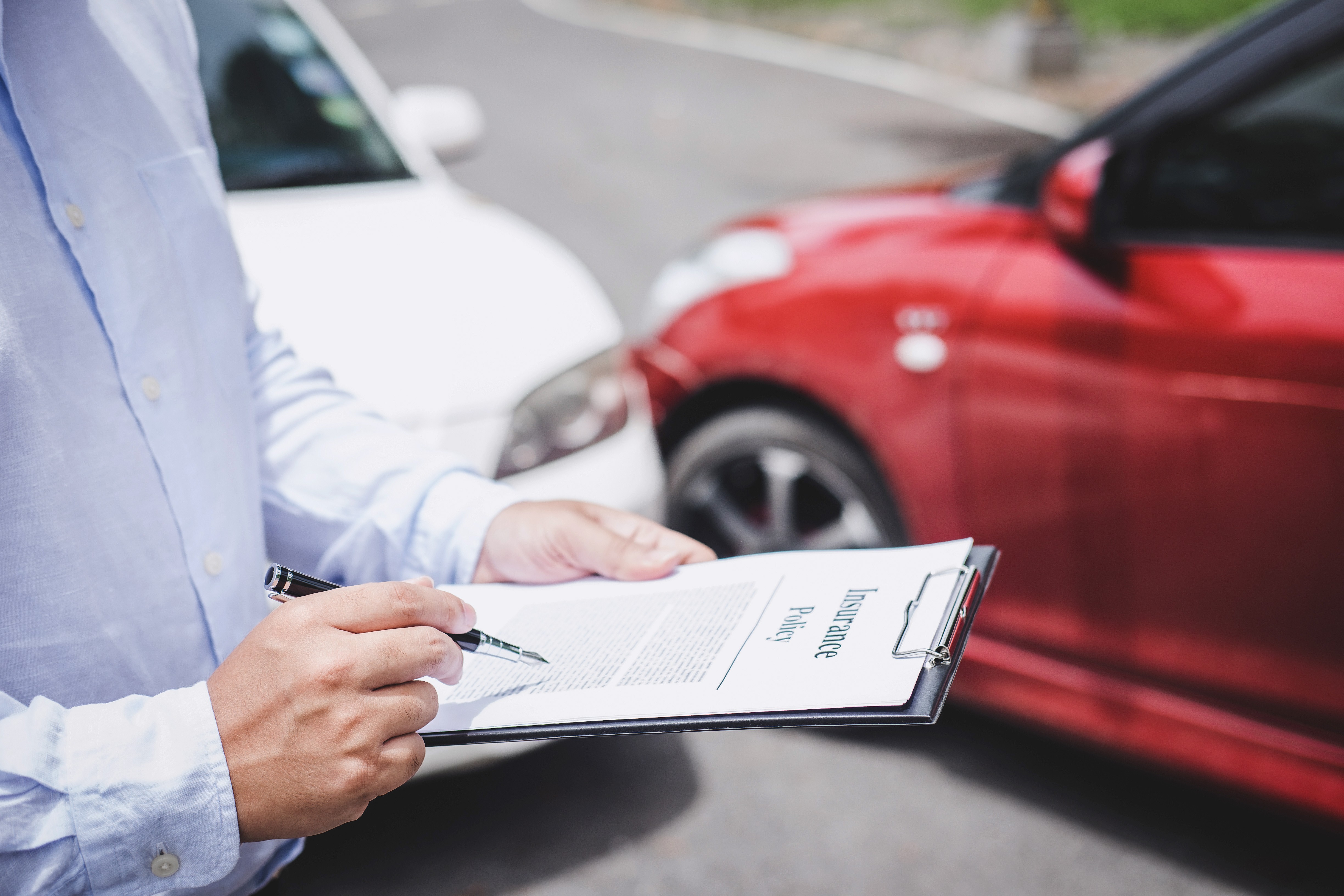 man revieing car accident policy at scene of accident