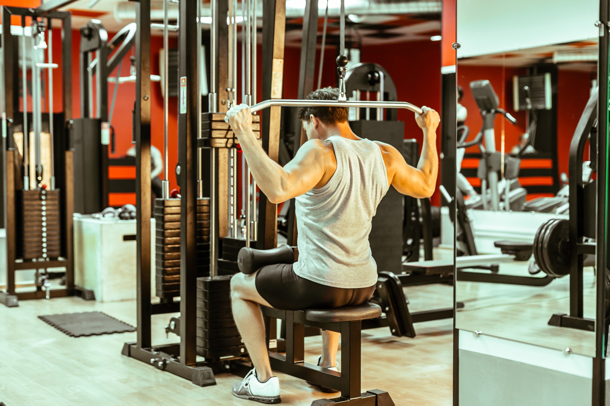 Man doing a lat pulldown exercise in a gym.