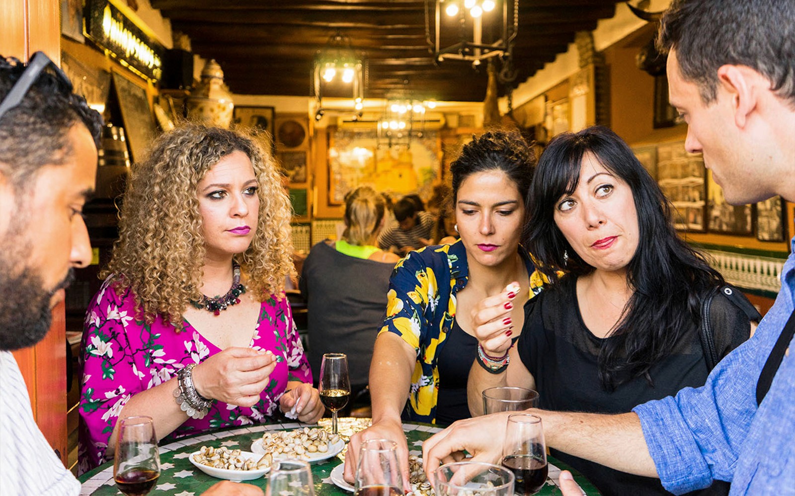 Group enjoying tapas and drinks at a traditional bar in Seville during a tasting tour.