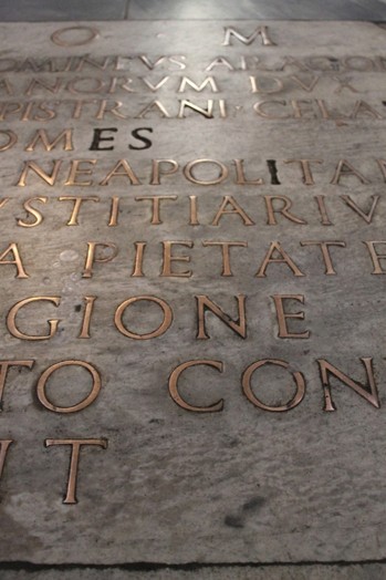 A stone plaque with embossed golden letters.