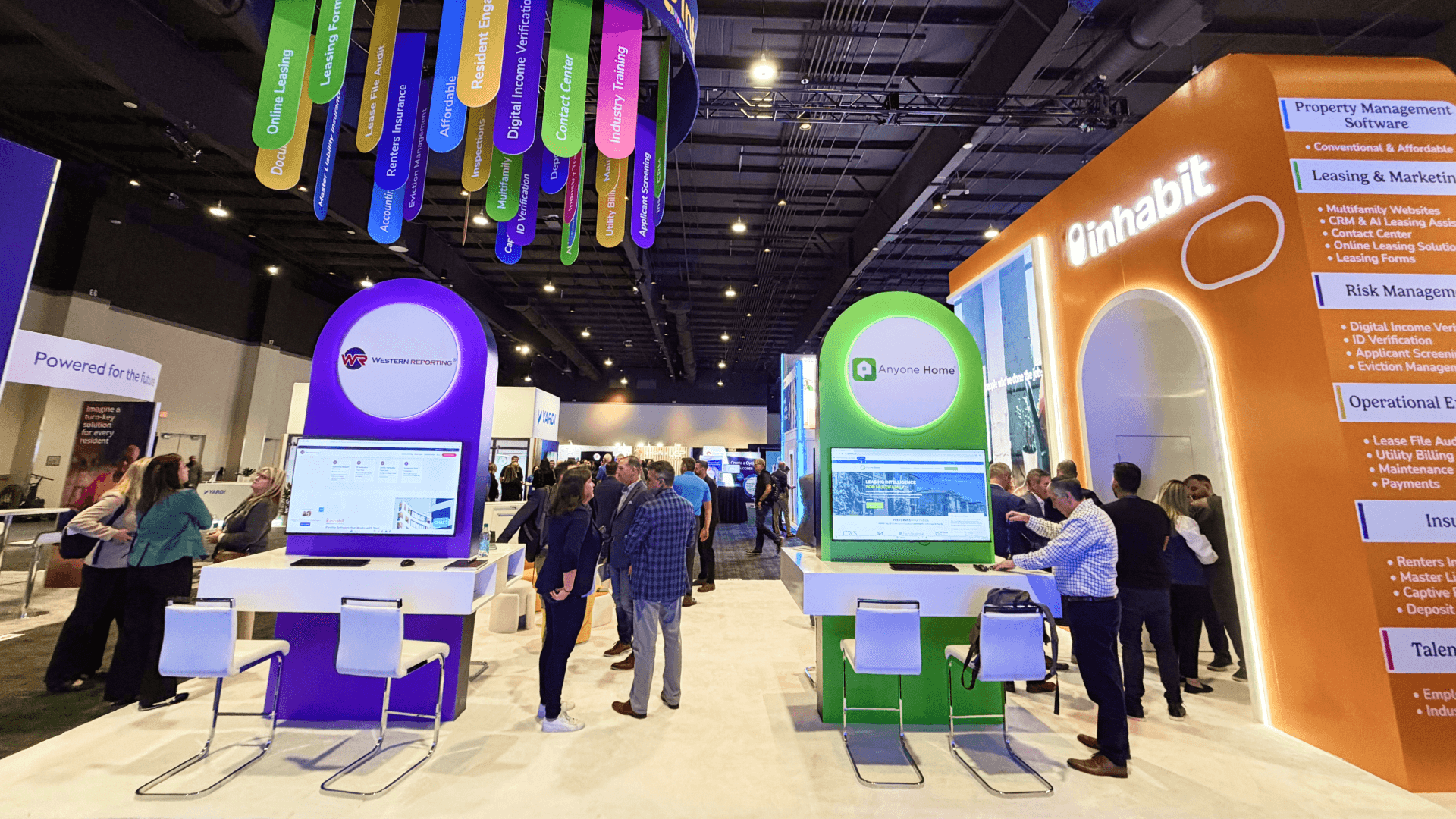 Interactive real estate software demo station inside Inhabit booth at OPTECH showcasing property management dashboards and rental housing technology platform