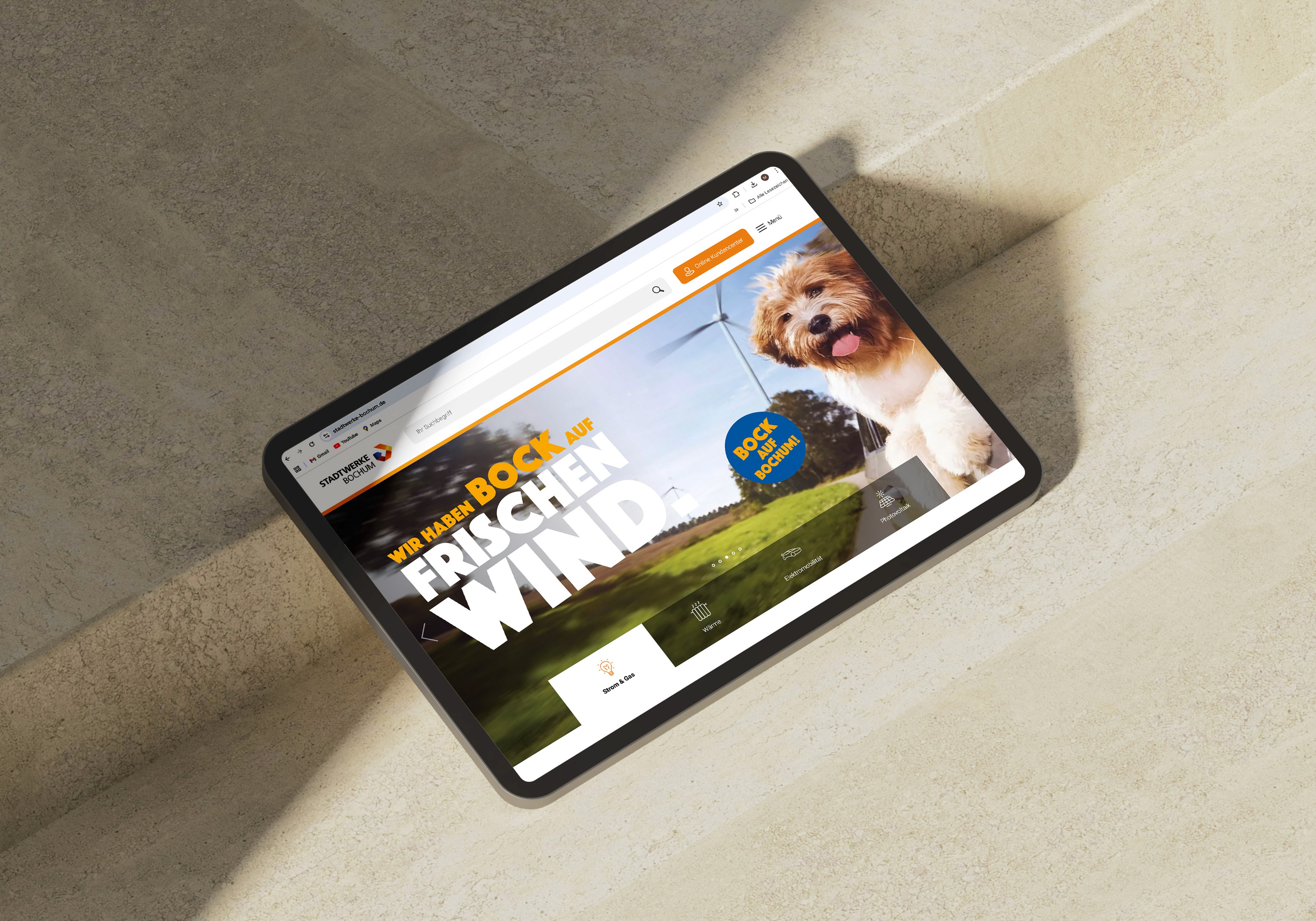 Tablet auf dem die Startseite der Stadtwerke bochum mit dem Kampagnenmotiv Frischer Wind, Windkraft und Hund zu sehen ist