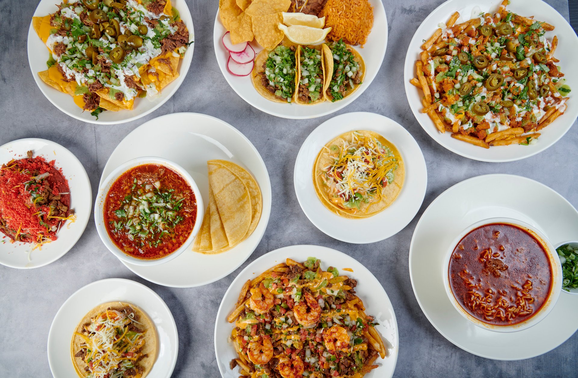 A spread of Fuego Cravings’ signature dishes, featuring quesabirria, birria ramen, and fresh tacos, ready to delight diners