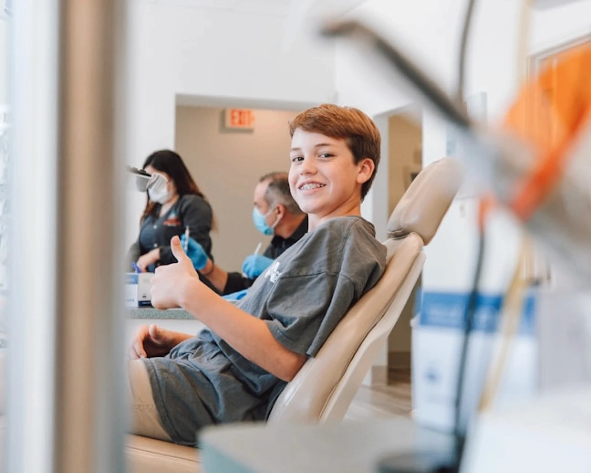 a man in a blue shirt is getting his teeth checked