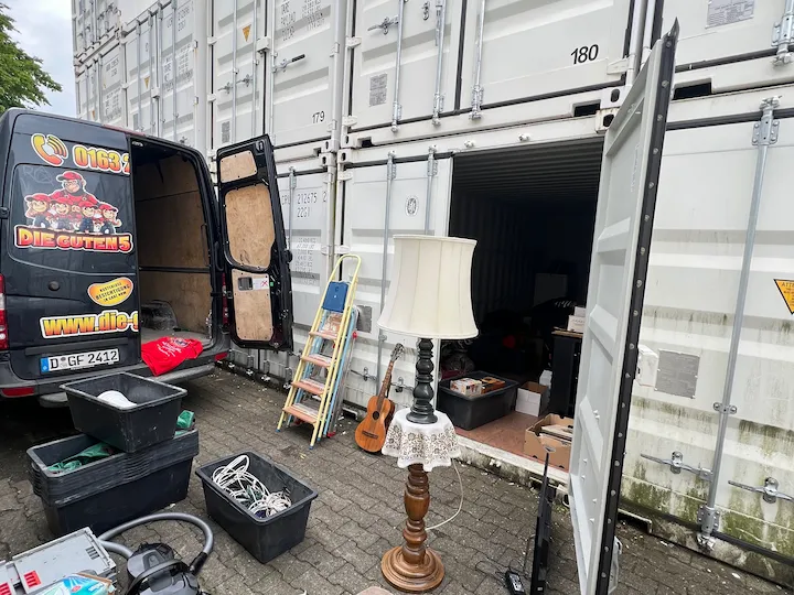 Hausrat wird vor geöffneten Lagercontainern sortiert und eingelagert