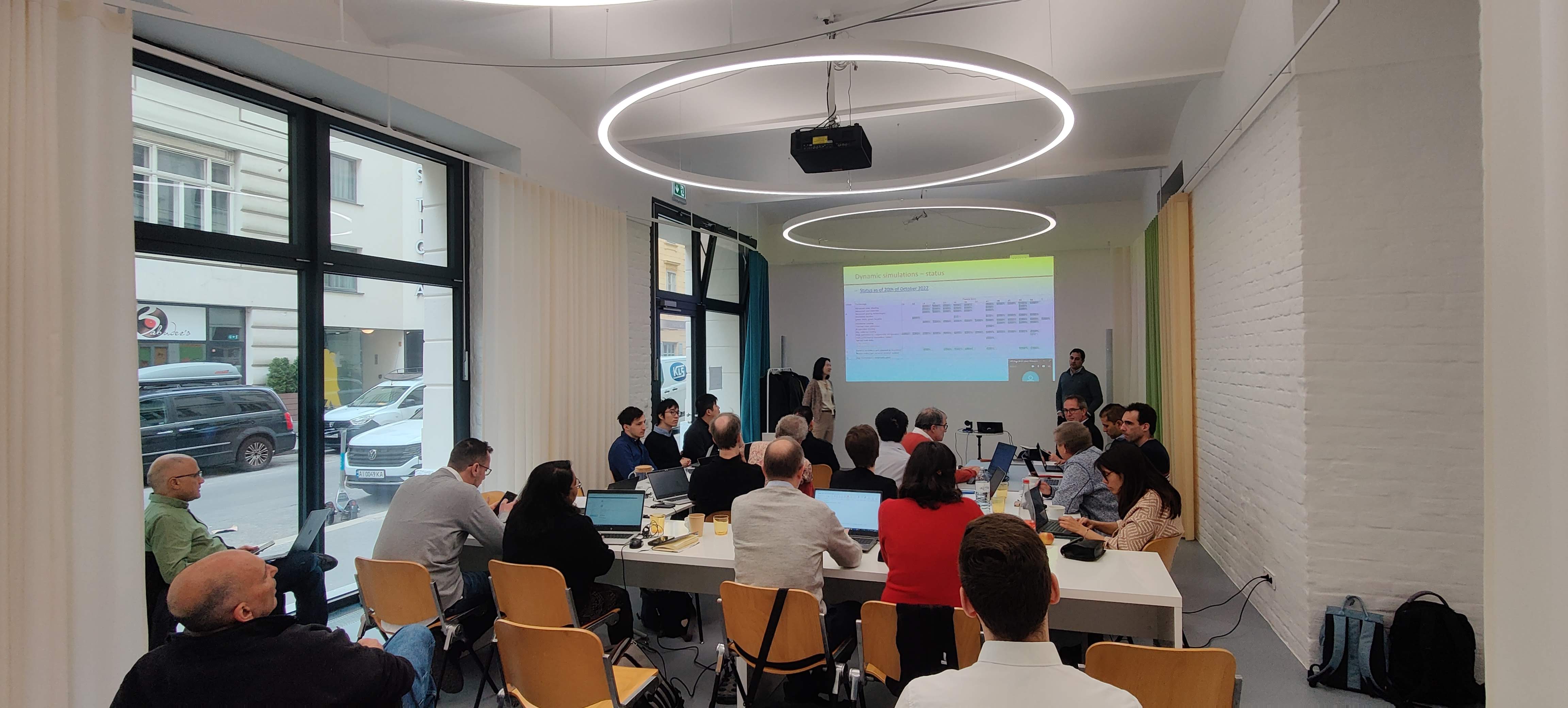A group of people gathered around tables in a spacious room, participating in discussions and collaborative work.