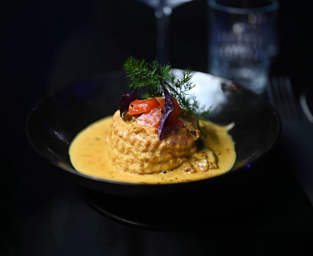 A beautifully presented gourmet dish with edible flowers, served on a restaurant table