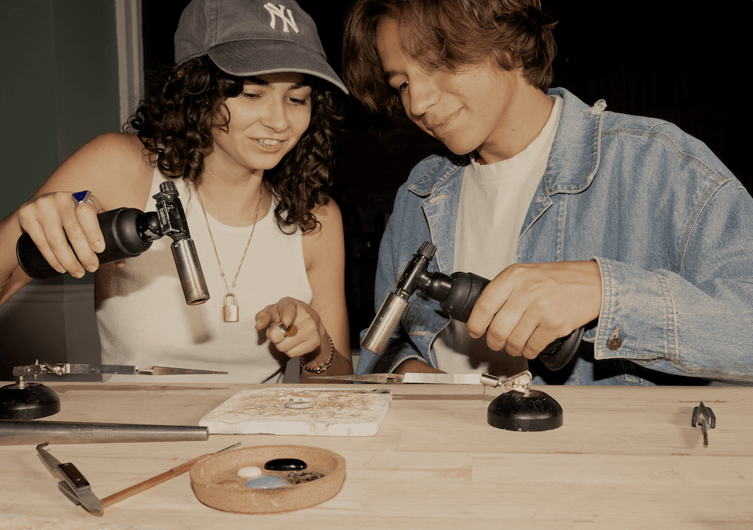 Couple using a blowtorch on jewelry
