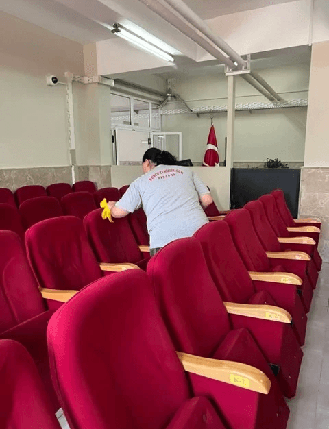 man in gray hoodie and blue denim jeans standing on brown wooden parquet flooring