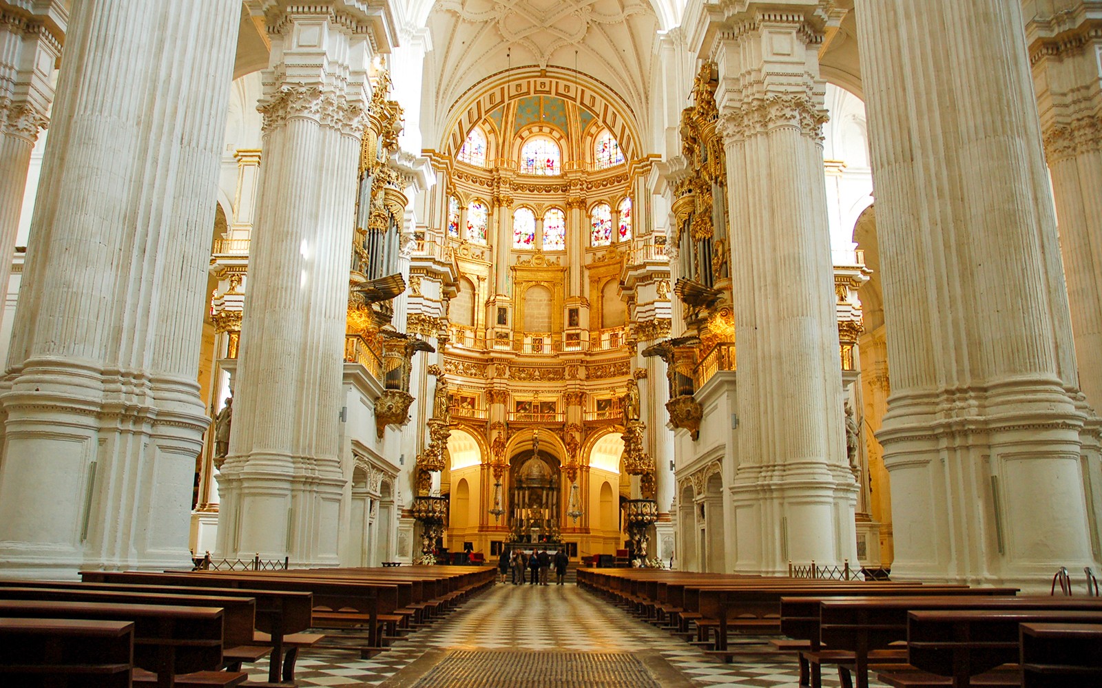 Interno della Cattedrale di Granada con colonne ornate e vetrate colorate, Spagna.