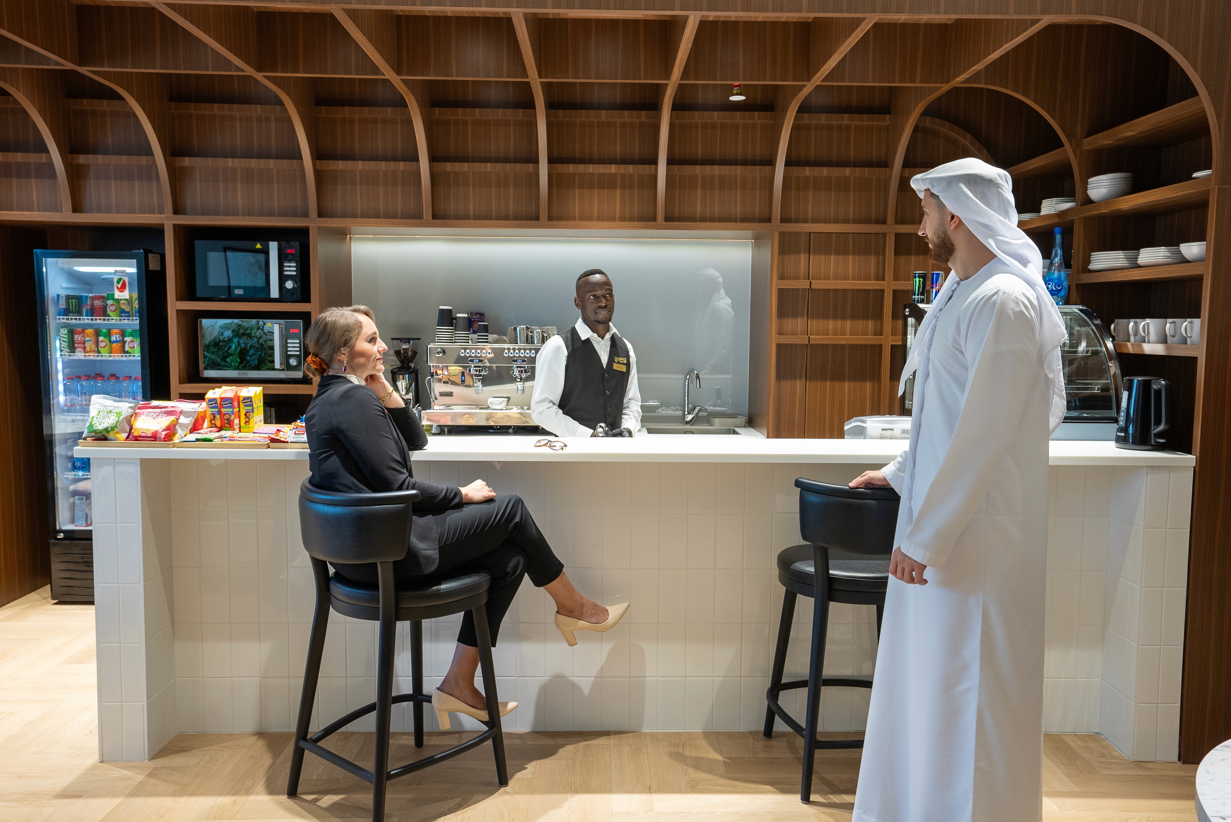 Barista serving guests at the café corner inside Office Square’s serviced office in Abu Dhabi.