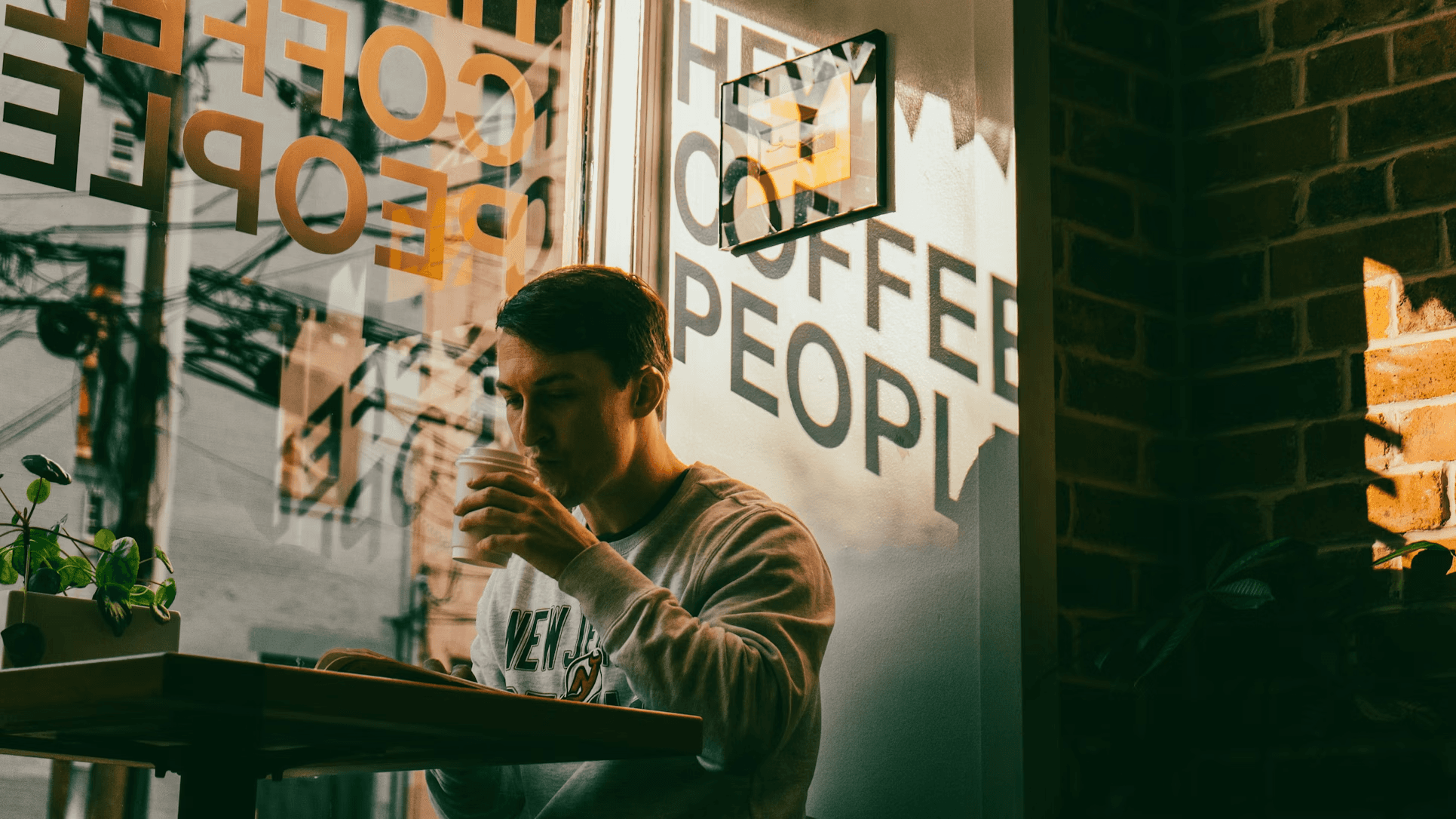 a man sitting at a table in front of a window