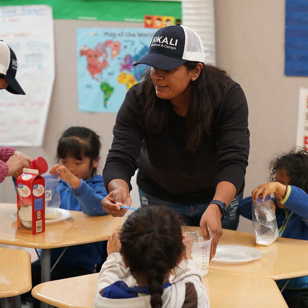 Instructor guiding students through step-by-step recipe in after school cooking program