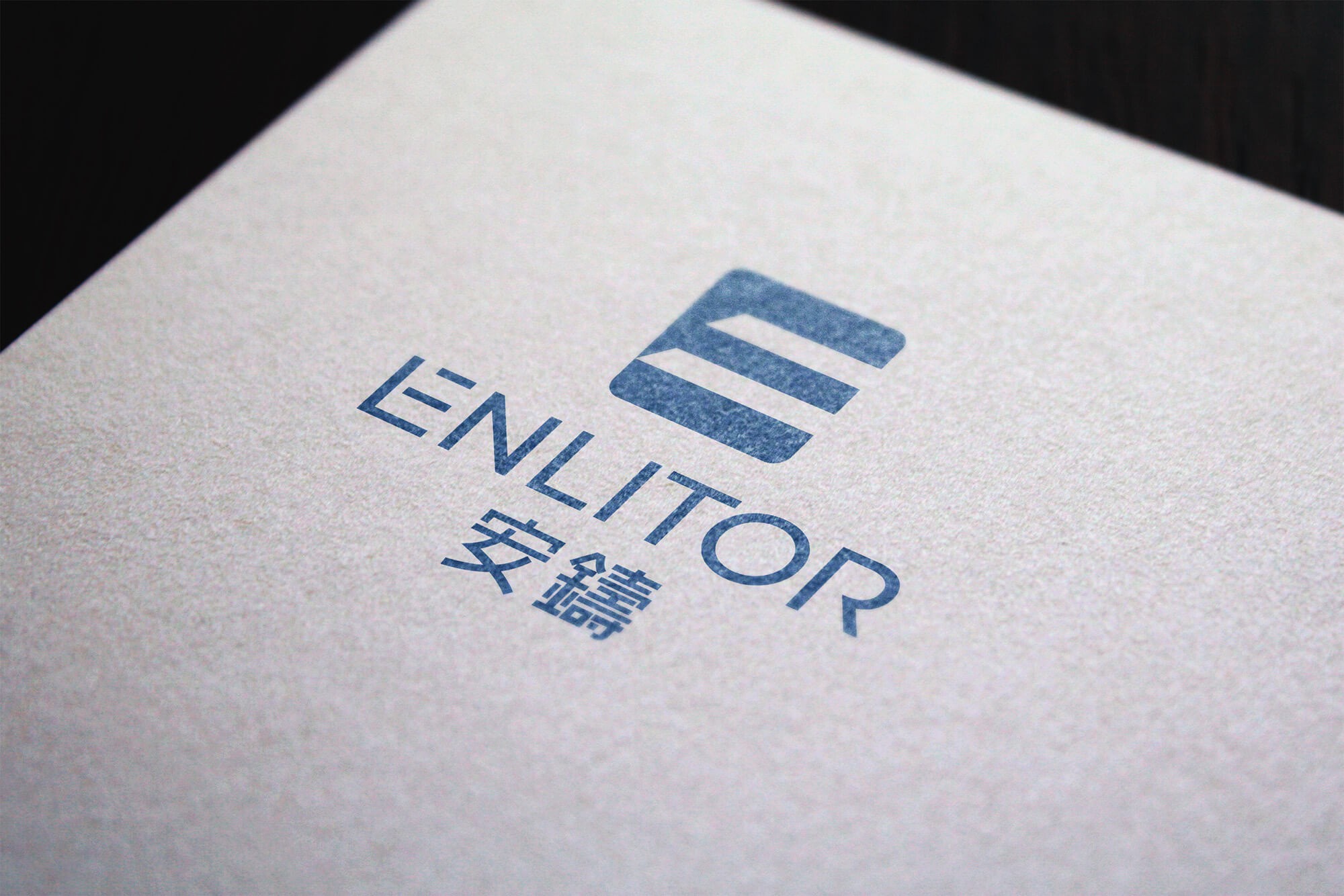 這張圖片展示了Enlitor的品牌識別設計。標識由三條橫線組成的字母「E」圖案,下方是「Enlitor」的英文名稱,使用了簡潔的無襯線字體。