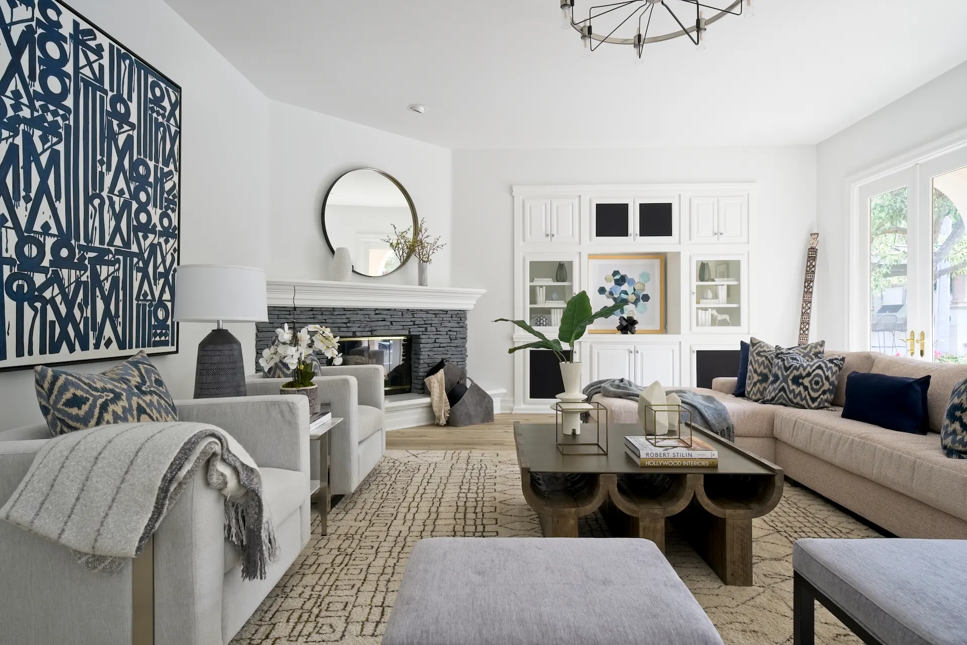 Full view of the living room from angle 1, showcasing boho furniture and decor, and an elegant fireplace, creating a cozy and stylish atmosphere. Photo by Todd Huge.