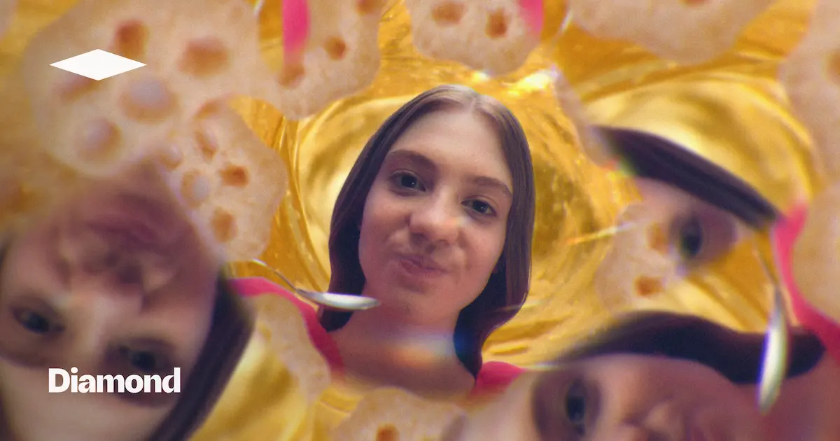 Close-up of a person's face centered against a golden honeycomb background with blurred mirrored faces