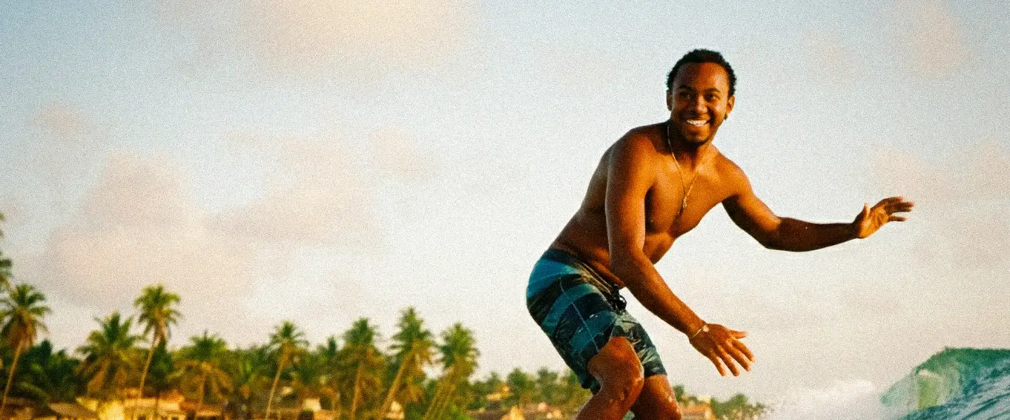 Local African surfer riding a wave on a beach, illustrating the authentic experiences you can book through BookAfrica, or for contacting support.