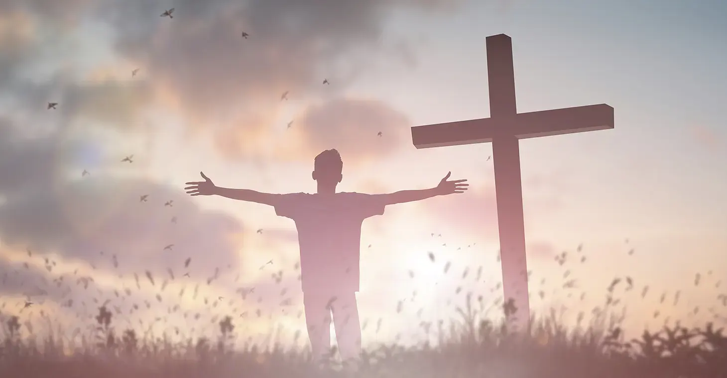 Illustrasjonsbilde av en person som priser Jesus foran et kors.