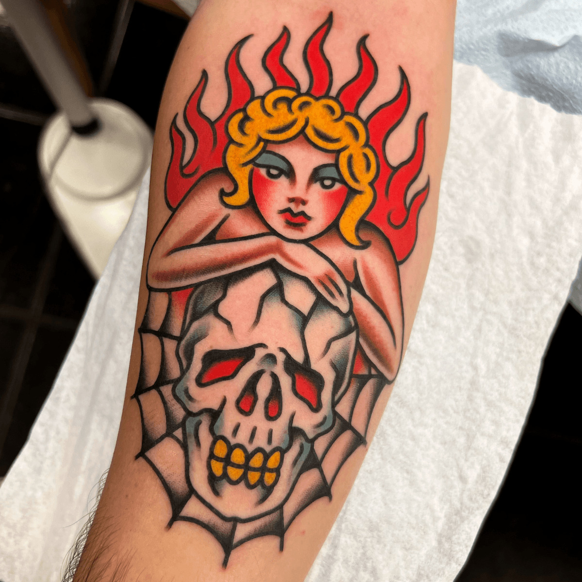 color tattoo of a pin-up girl with a skull and flames