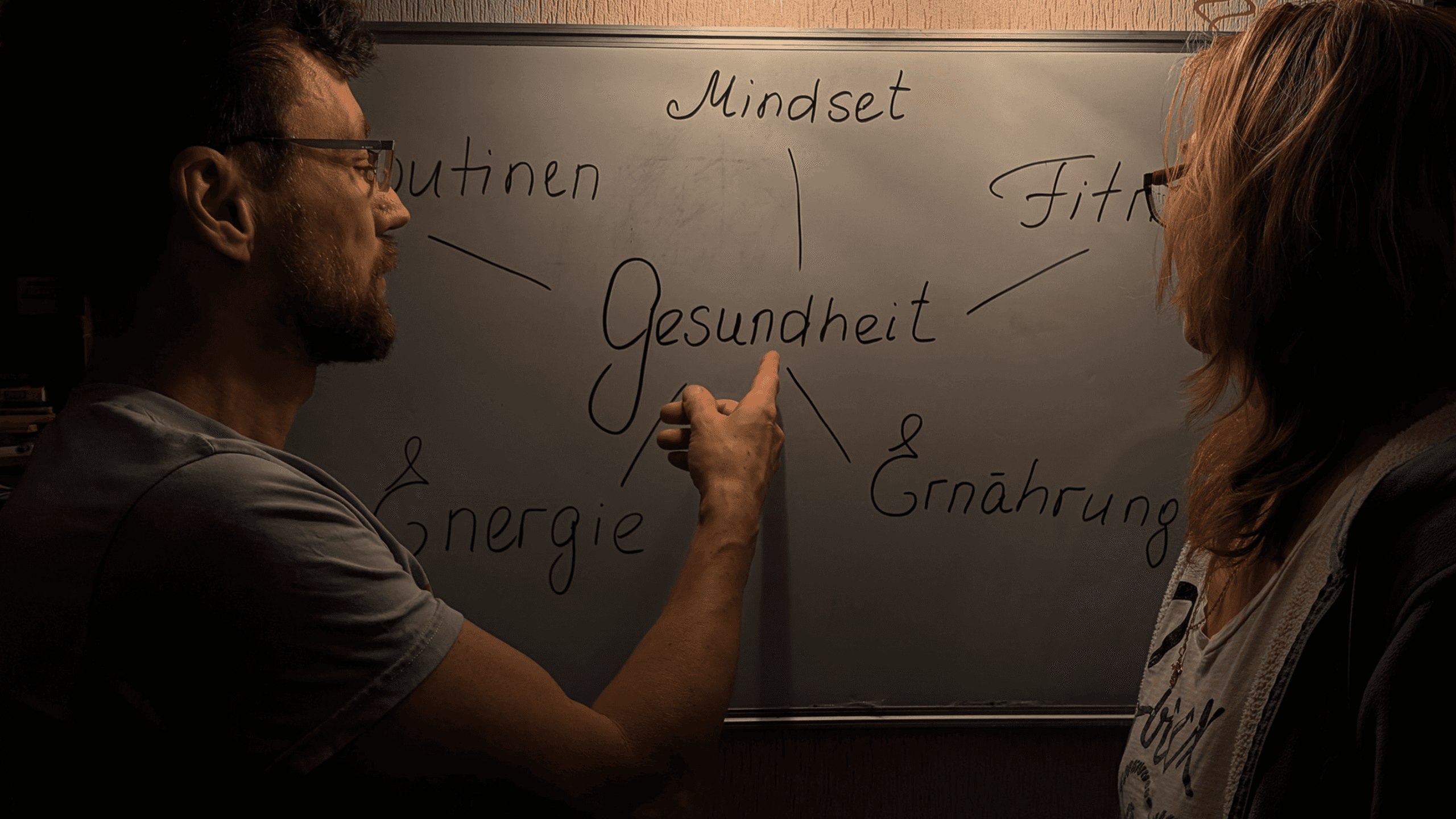 man wearing gray polo shirt beside dry-erase board
