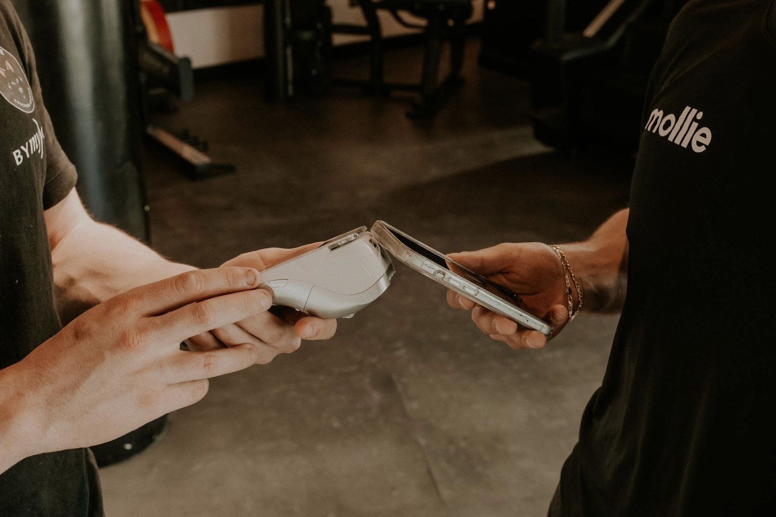 In a gym, an employee accepts a payment on a Mollie terminal.
