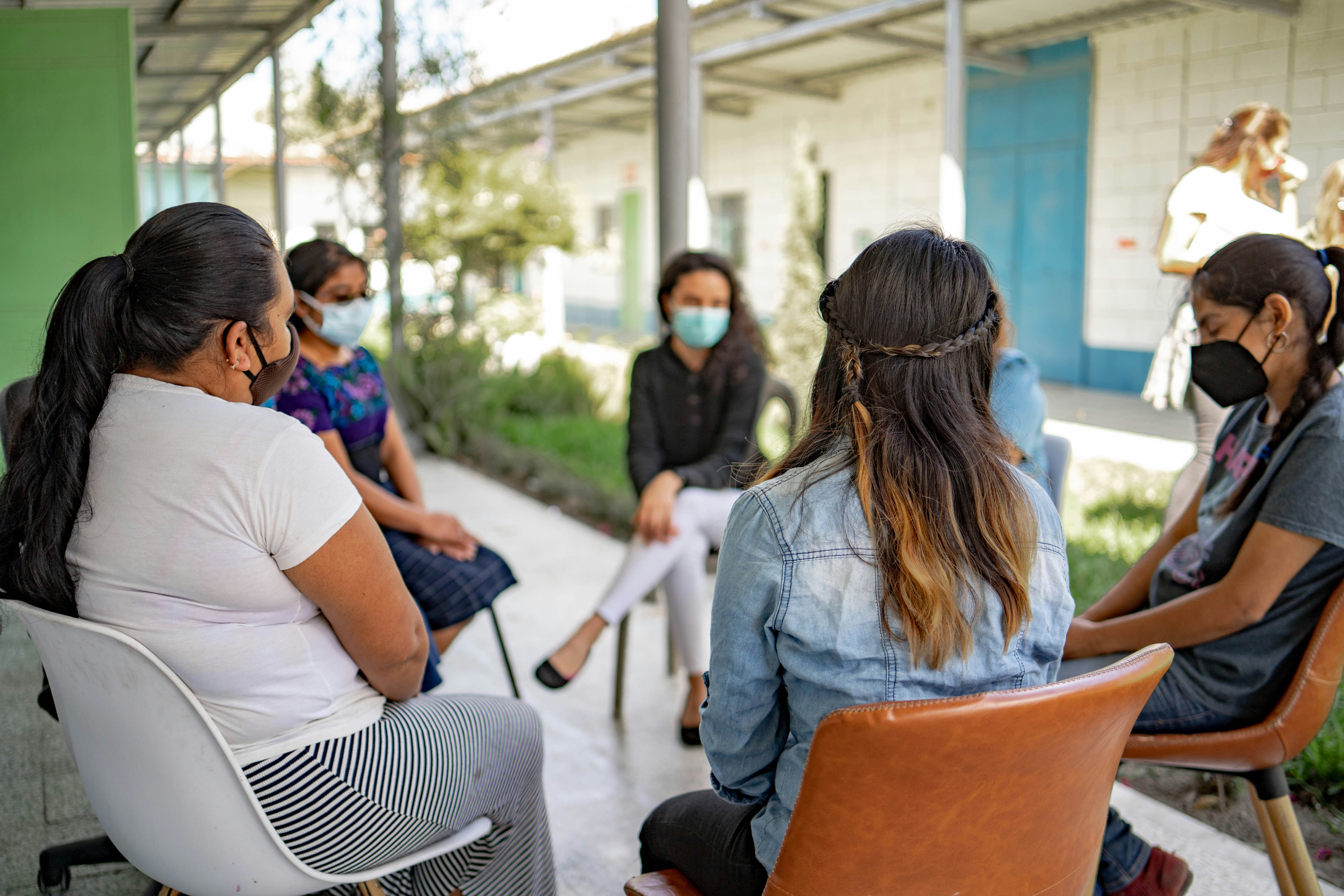A group of people sitting around each other