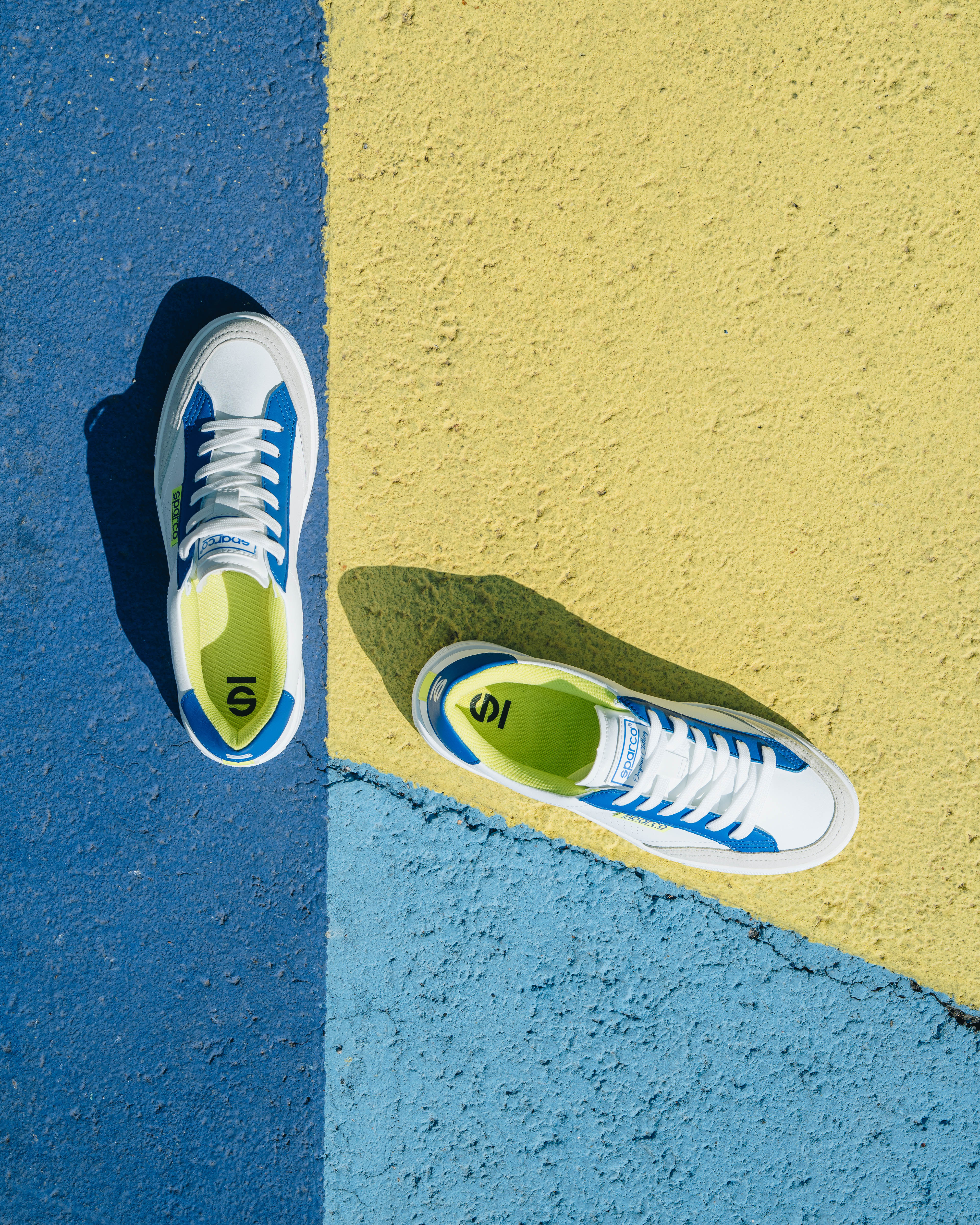 Render vista tre quarti frontale di Kia EV6 in ambiente architettonico moderno e minimalista in stile advertising.