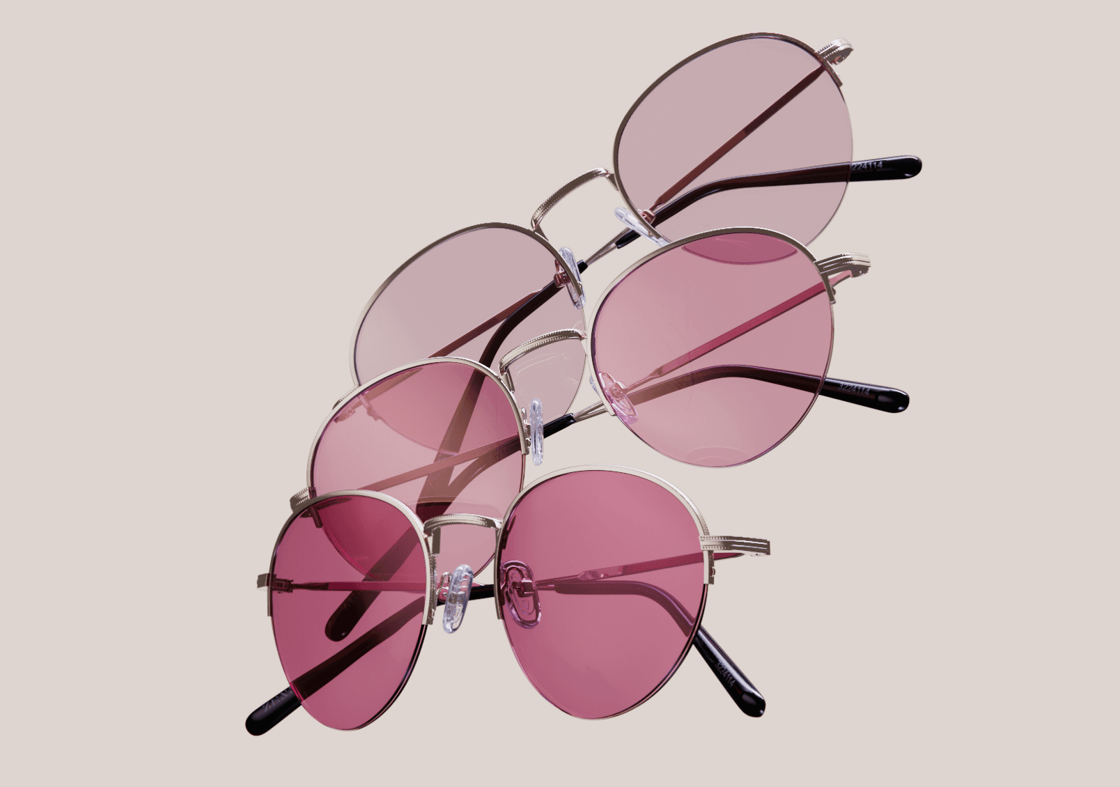 Three Zenni round metal frames with FL-41 rose-tinted lenses stacked diagonally against a warm neutral background