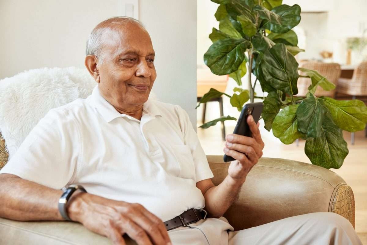 Senior man checking blood pressure at home with digital monitor