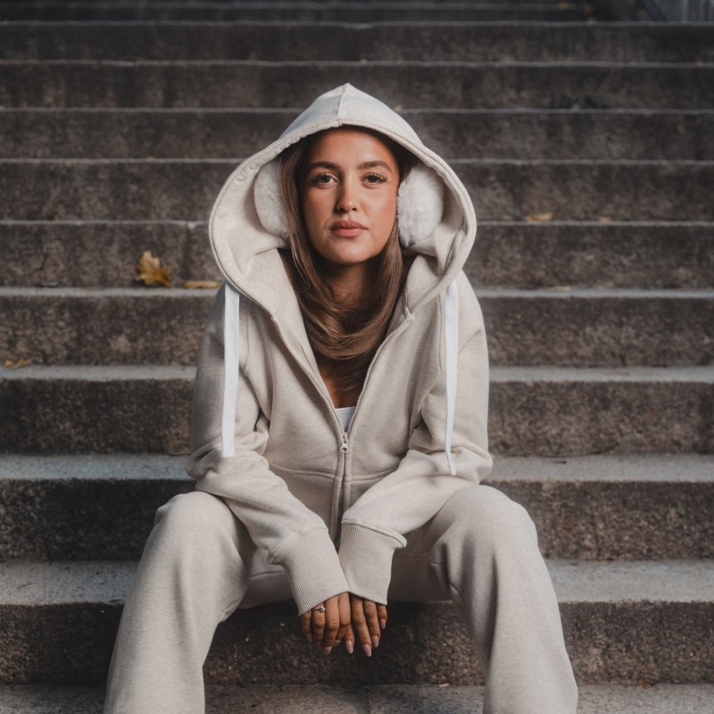 Woman sitting on stairs with a cream colored Russemerch set