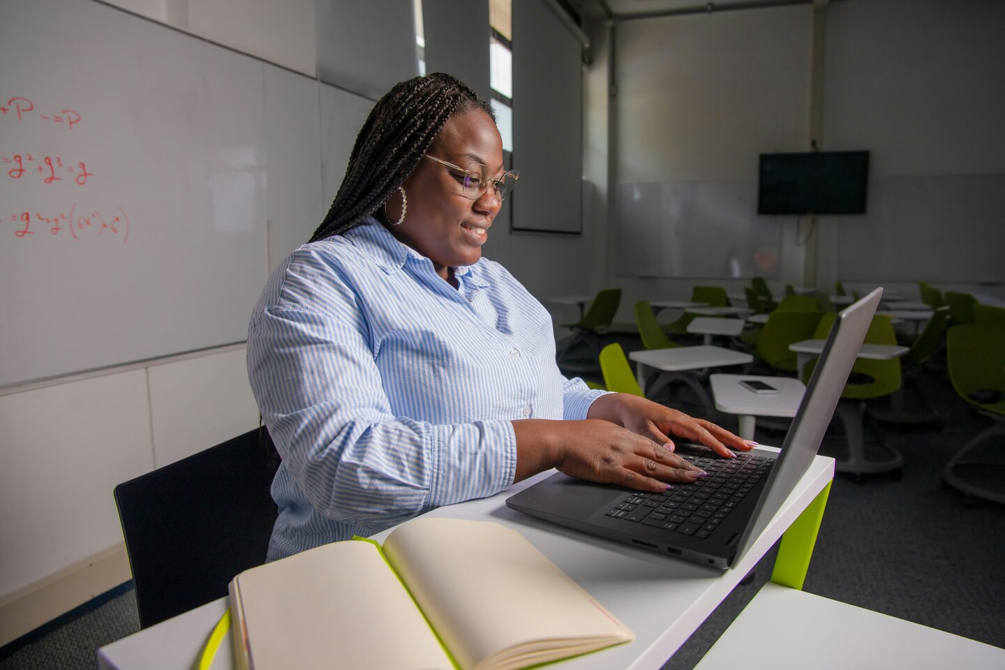 two women talking while looking at laptop computer