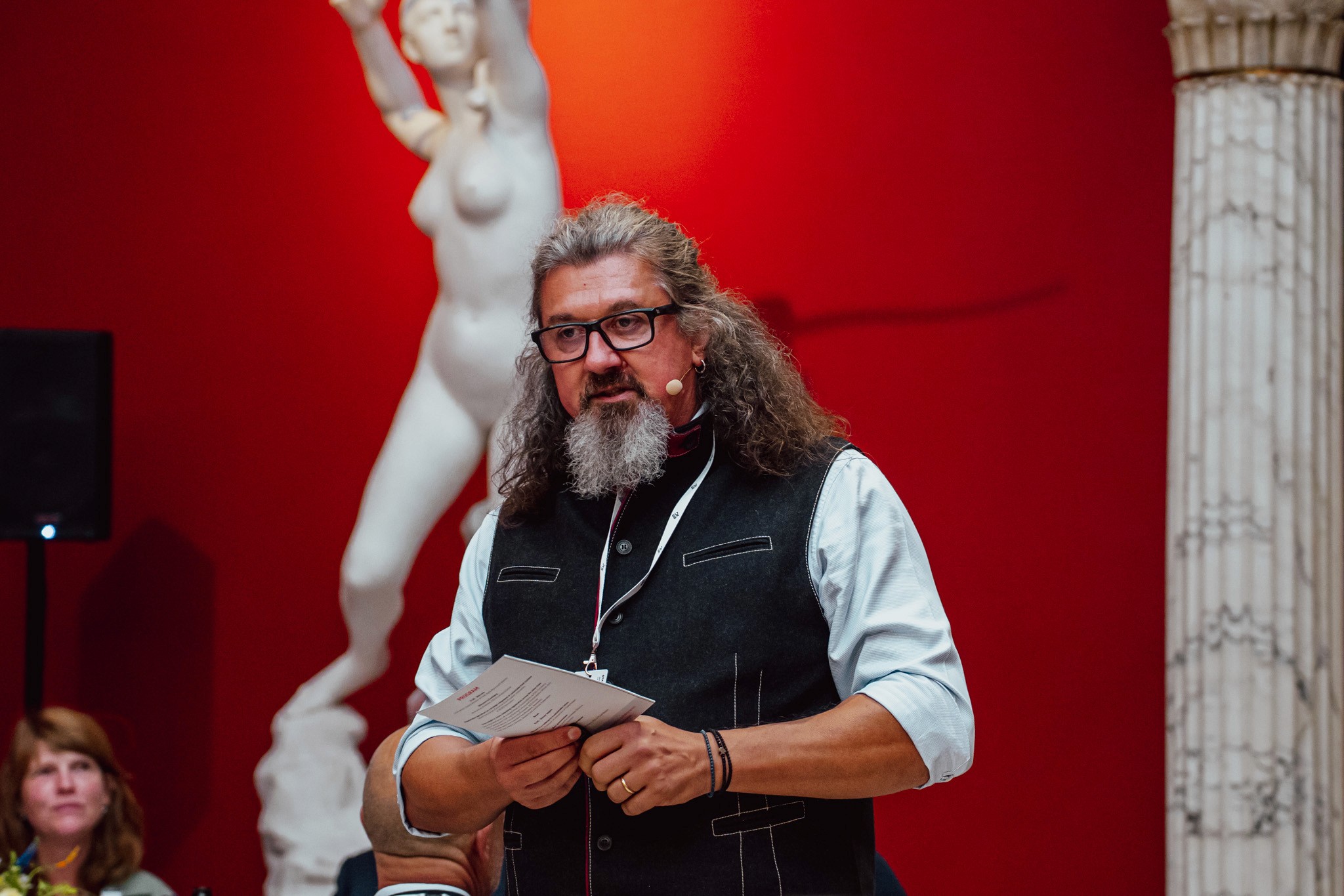 Person stand in front of a red sports oldtimer