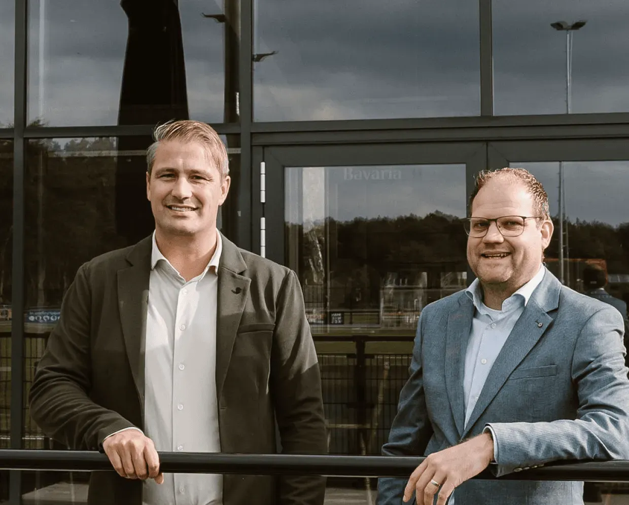 Twee BMVV-medewerkers staan voor het kantoor