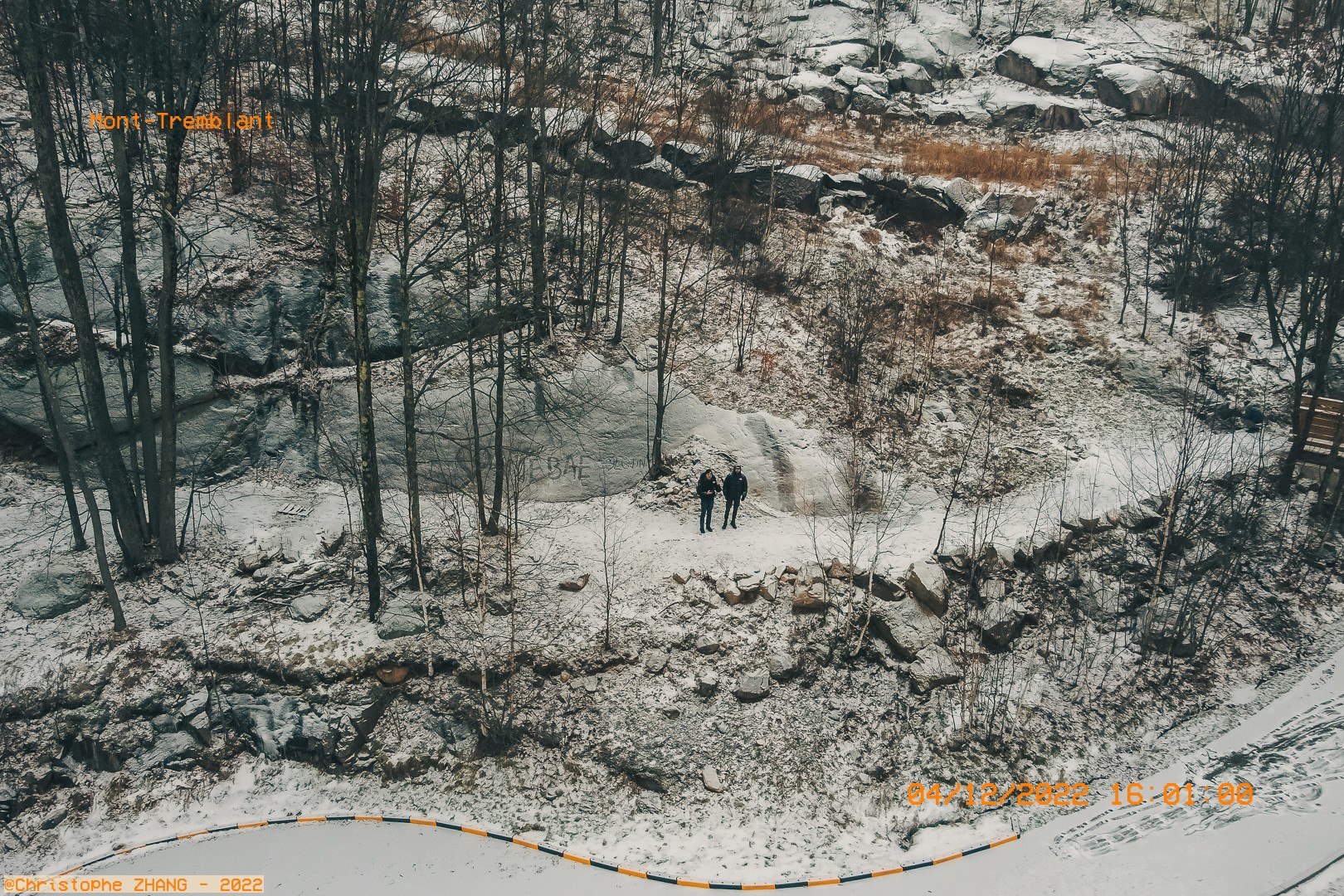 Randonnée hivernale le long d'un chemin forestier enneigé à Mont-Tremblant, vue depuis un point élevé.